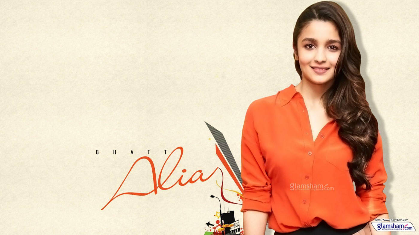 Alia Bhatt 穿著橙色襯衫微笑，身後有風格化文字和圖形。