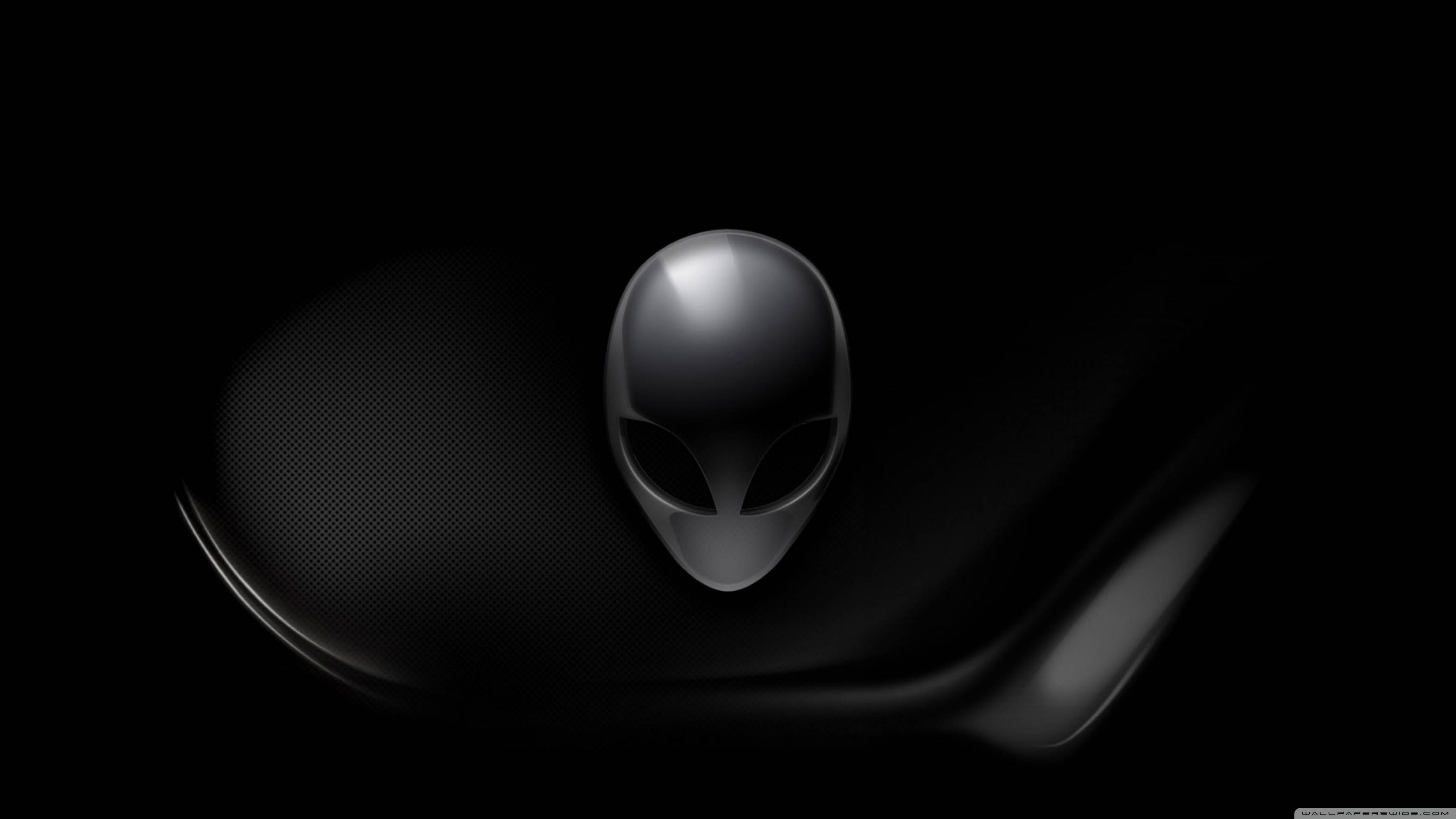 Alienware 超高清遊戲力量 壁紙 — 一個光滑的金屬外星人頭標誌在深色紋理背景上閃耀，帶有平滑彎曲的陰影。