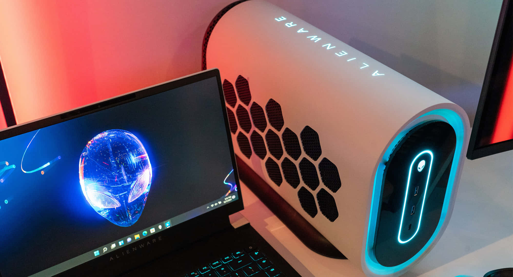 Retina Ready Alienware 壁紙 — Alienware 遊戲筆記型電腦和主機在黑暗背景下發出藍色和紅色霓虹燈光。