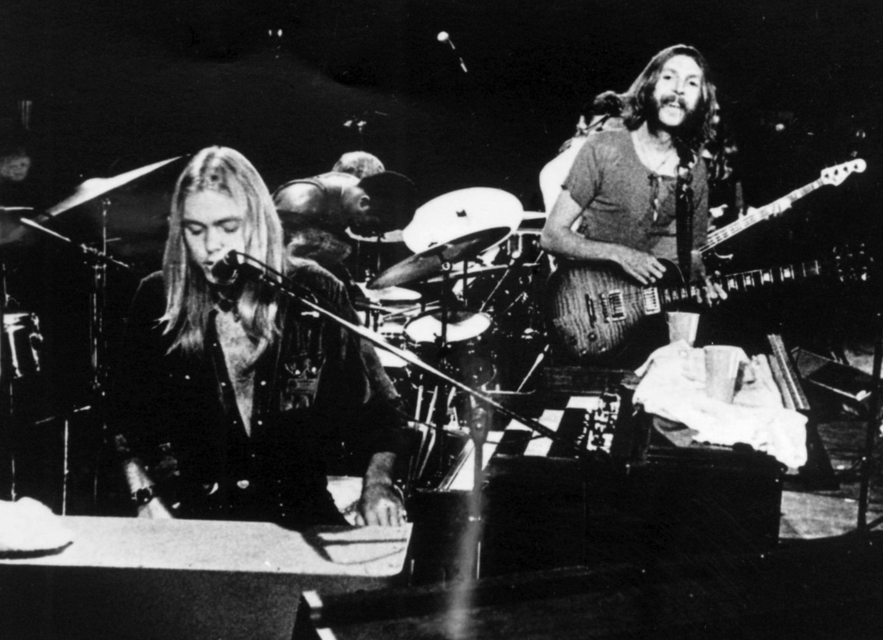 Allman Brothers Band 吉他手 壁紙 — 兩位音樂家在舞台燈光下用鍵盤和低音結他現場表演的黑白照片。
