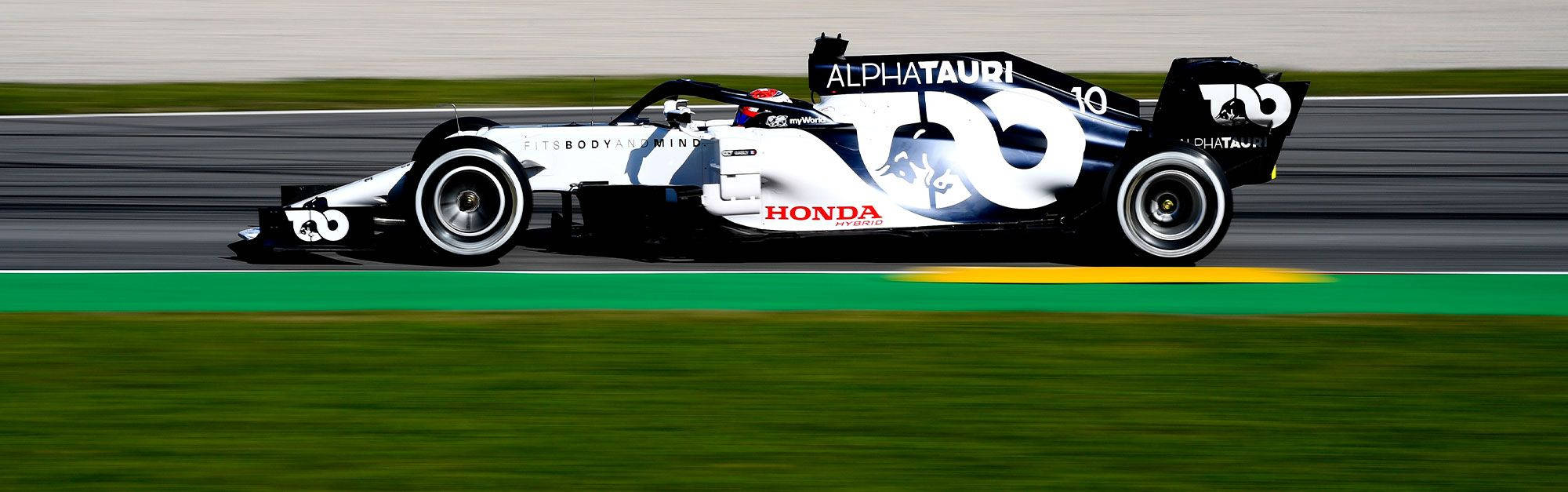 AlphaTauri Honda一級方程式賽車在賽道上奔馳，帶有動態模糊效果。