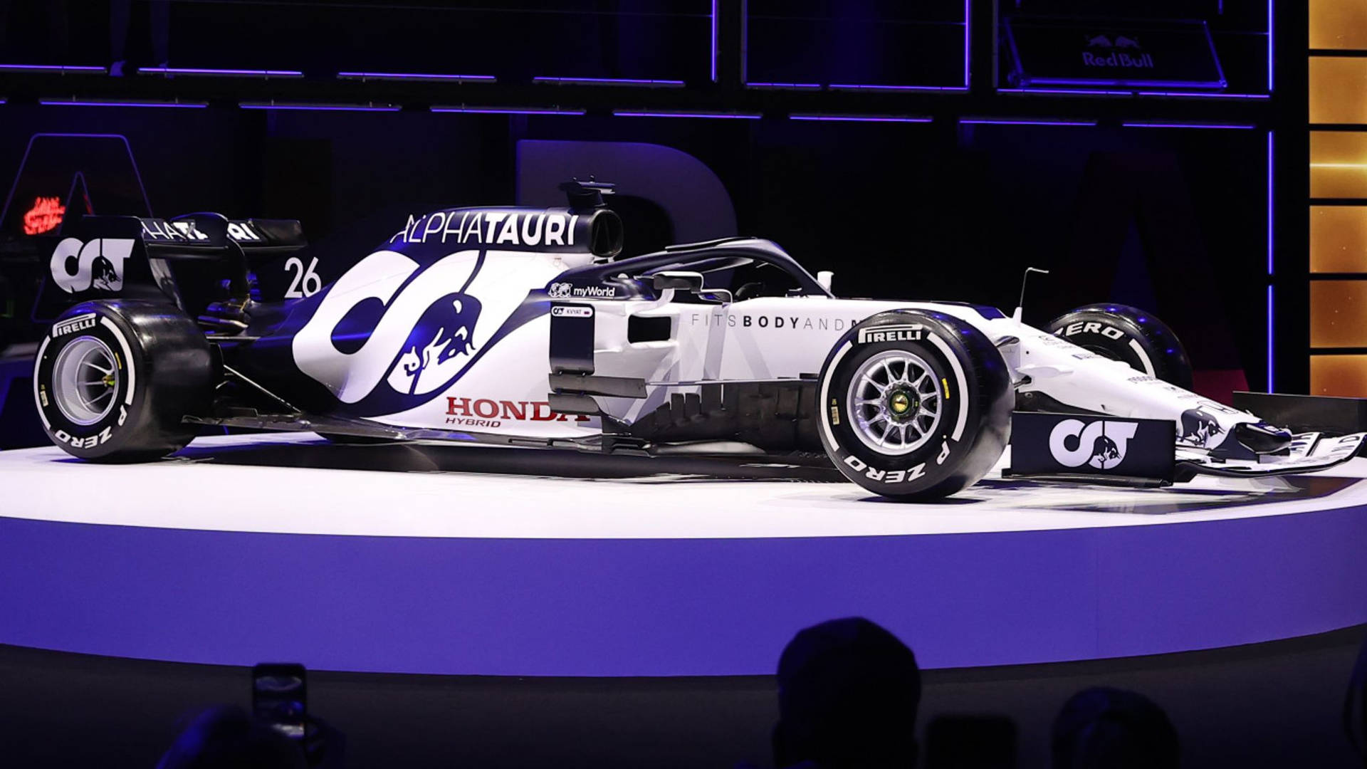 AlphaTauri F1賽車26號在紫色燈光照亮的舞台上。
