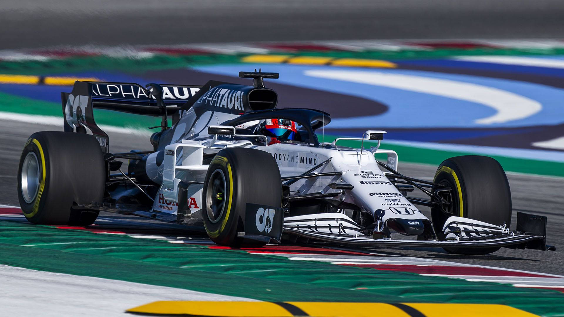 AlphaTauri F1賽車在色彩繽紛的賽道上比賽，車手清晰可見。