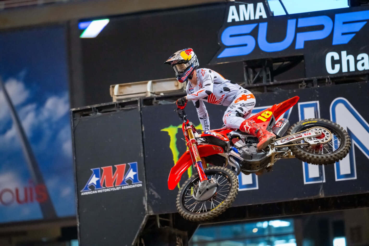  壁紙 — AMA Supercross Championship 賽事中，紅色越野電單車車手在體育館跳台上凌空飛翔。
