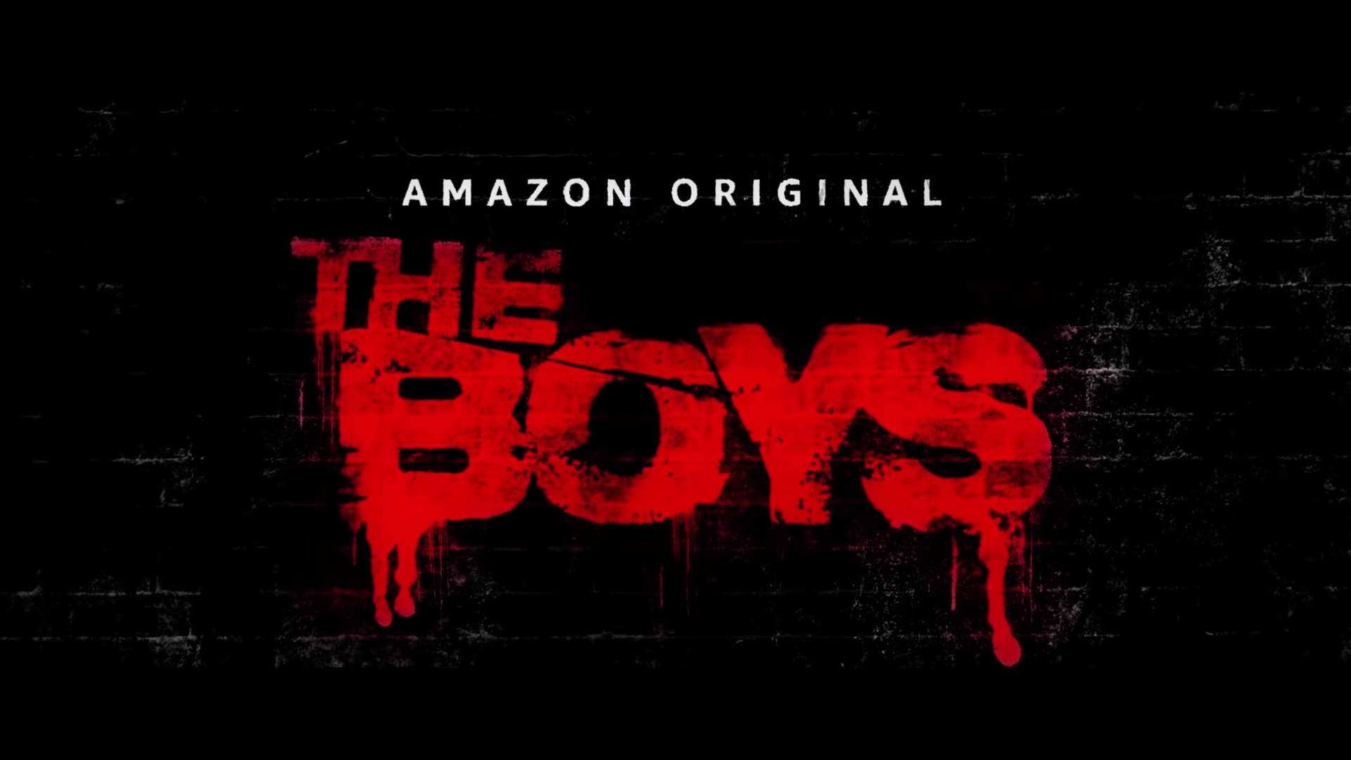 黑色磚牆上帶有滴落油漆的紅色塗鴉文字「The Boys」。