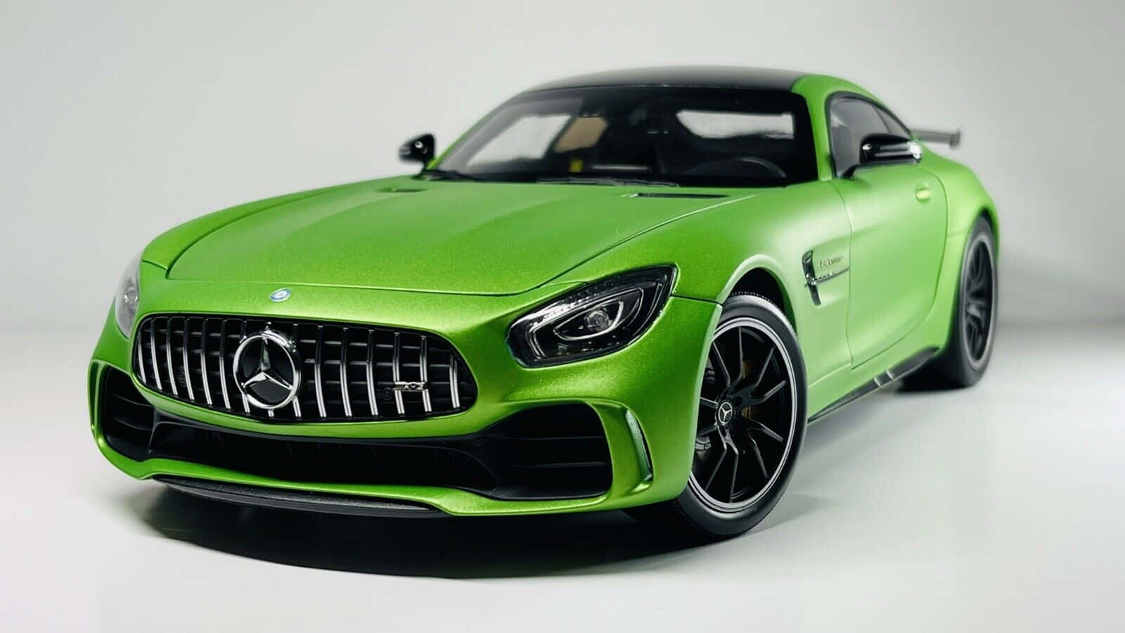 最佳梅賽德斯-AMG GT-R 2017 跑車背景 壁紙 — 充滿活力的啞光綠色 Mercedes-AMG GT 跑車模型，帶有黑色點綴和精細格柵，置於潔白的工作室背景上。