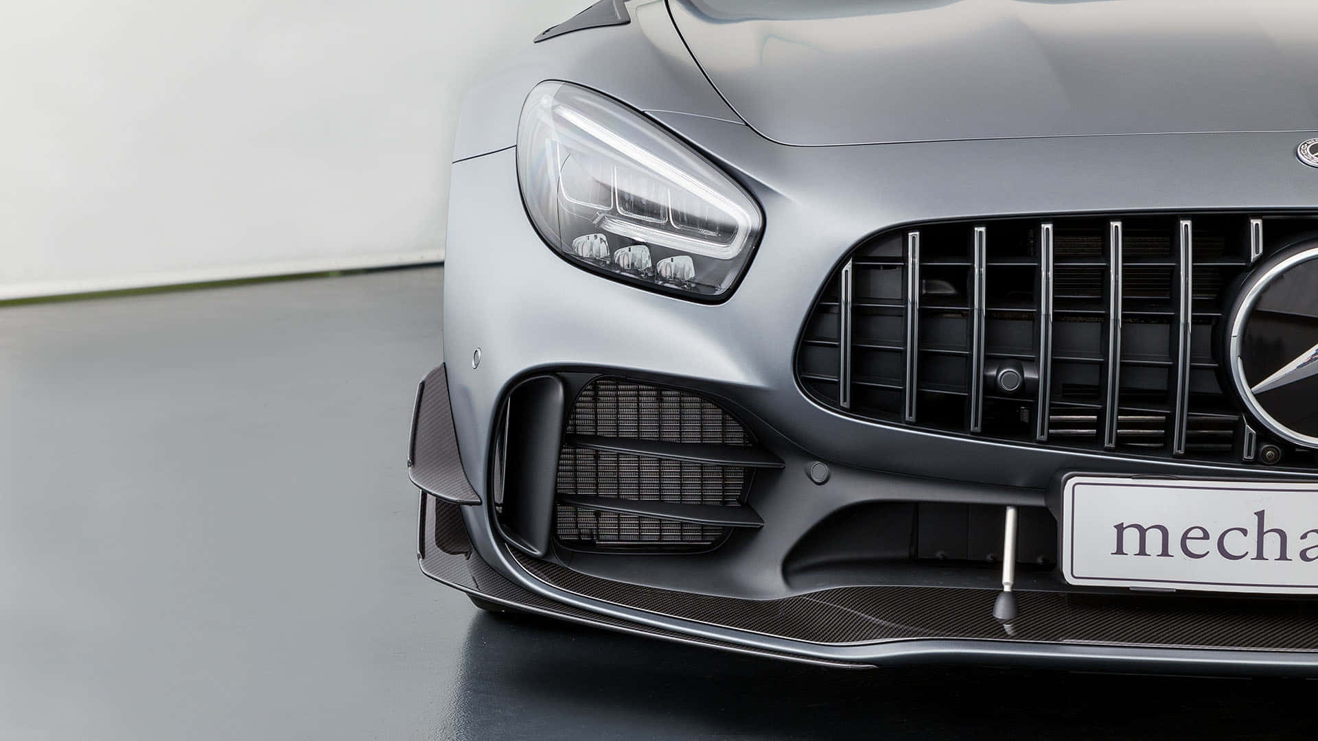 最佳 AMG GT-R 2018 頭燈背景 壁紙 — 在簡約工作室環境中，時尚銀色 Mercedes-AMG 跑車的前格柵和頭燈特寫。