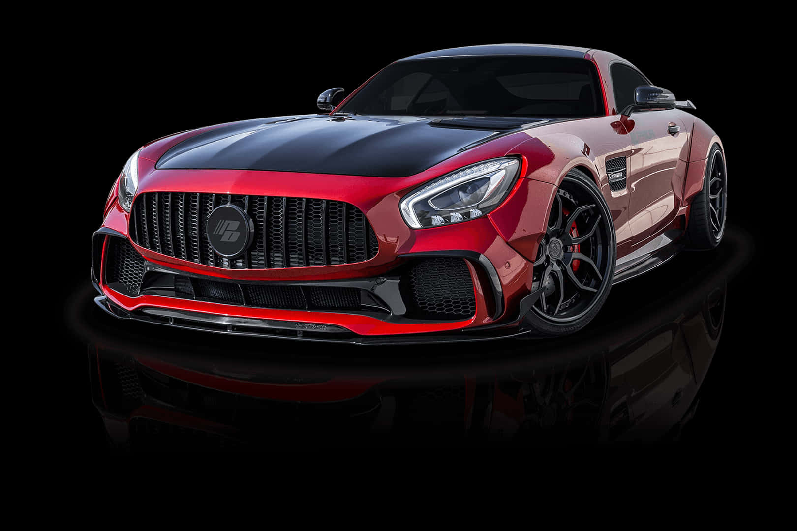 體驗速度與奢華——最佳AMG GT-R 壁紙 — 一輛引人注目的紅黑配色跑車，具有侵略性造型和發光頭燈，停在反光的黑色表面上。