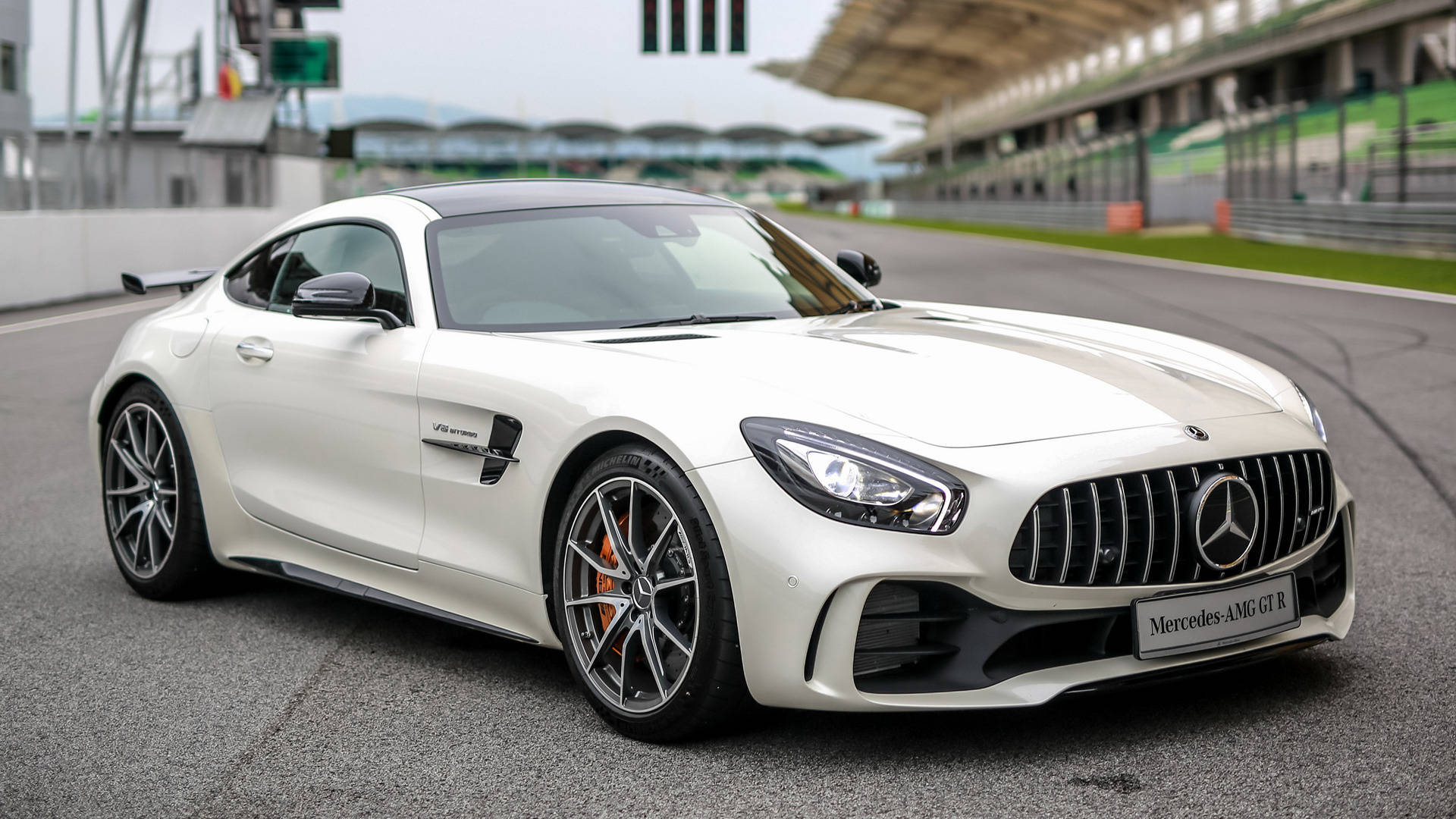 白色Mercedes-AMG GT R在賽道上，背景有觀眾席。