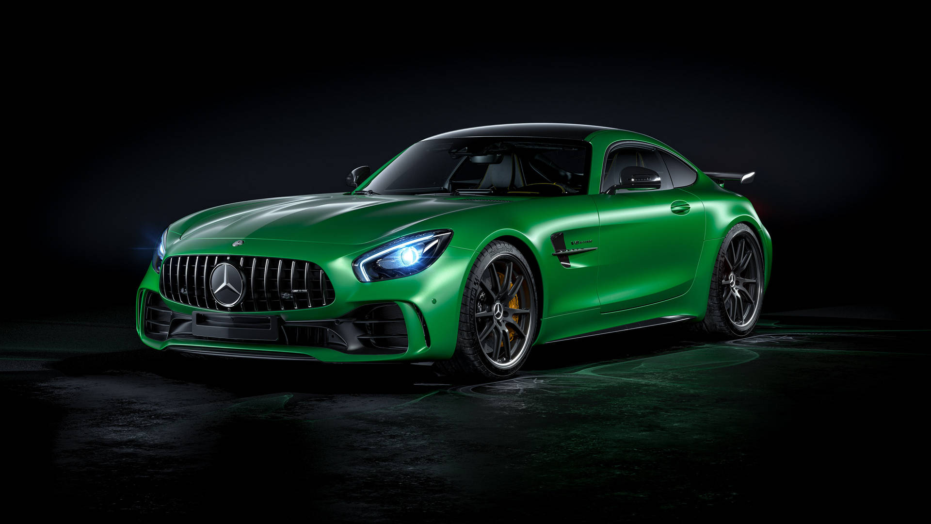 深色地板上的綠色 Mercedes-AMG GT R 跑車在攝影棚燈光下。
