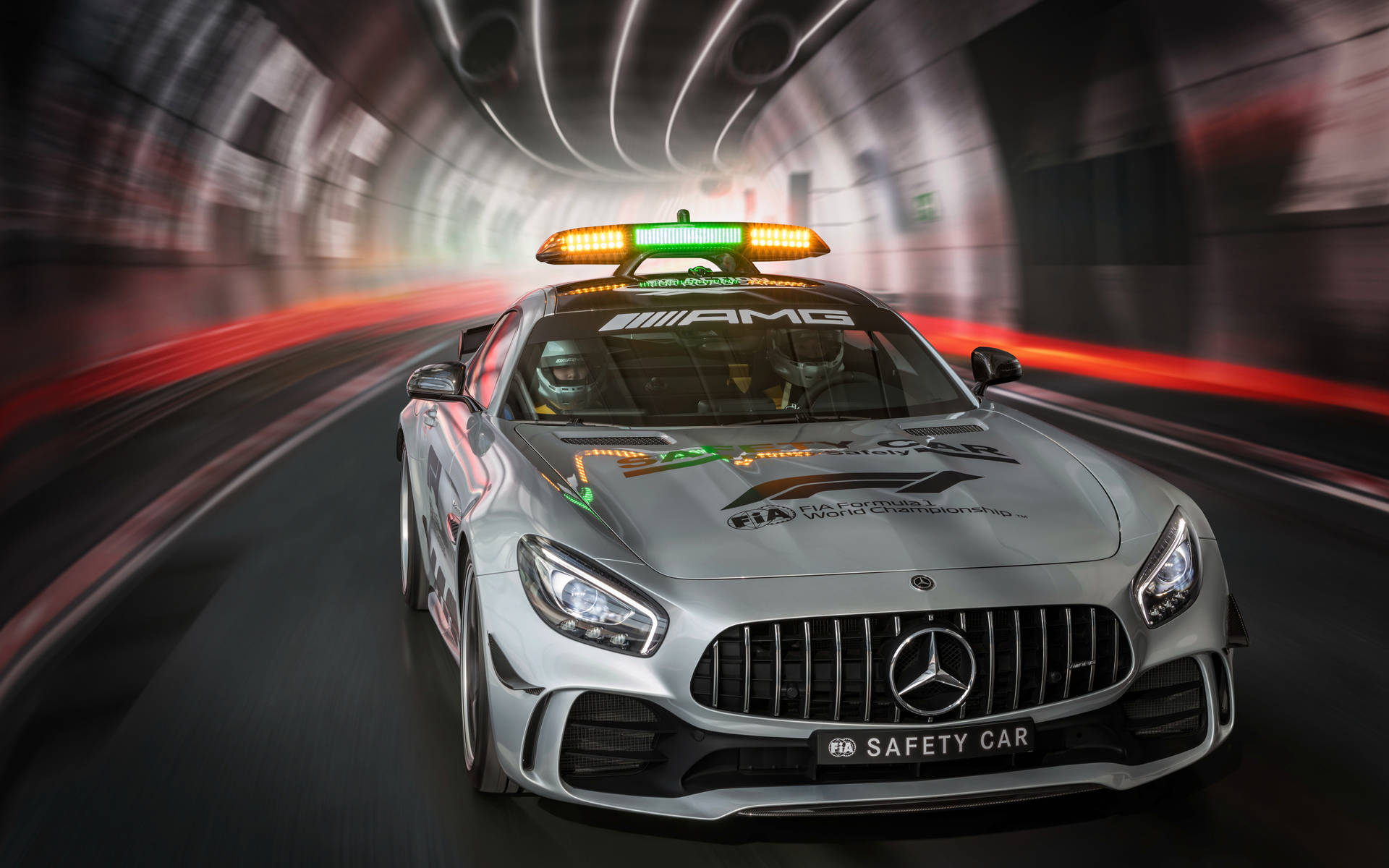 銀色 Mercedes-AMG FIA 安全車在隧道中高速行駛，燈光模糊。