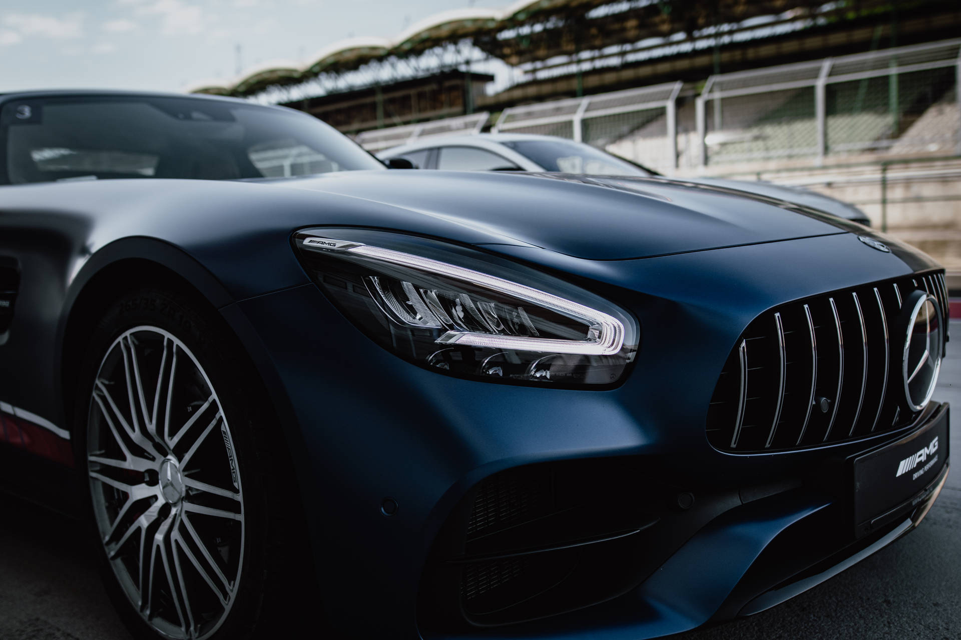 啞光藍色 Mercedes-AMG GT 跑車在賽車場上。