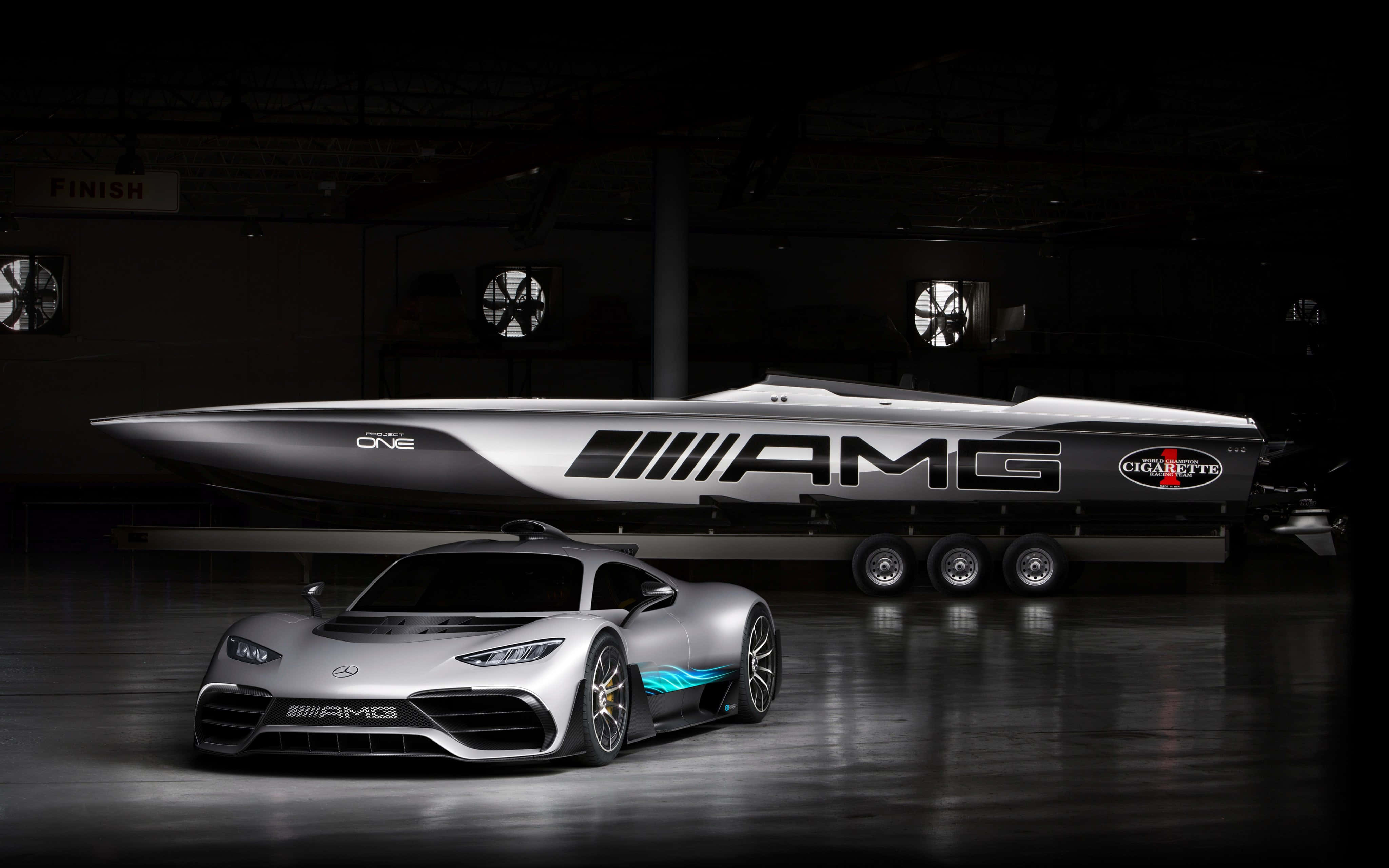 梅賽德斯-AMG Project One 與 Cigarette Racing 船隻競速背景 壁紙 — 一架時尚的銀色AMG跑車和相配的快艇在黑暗的工業車庫中被戲劇性地照亮。