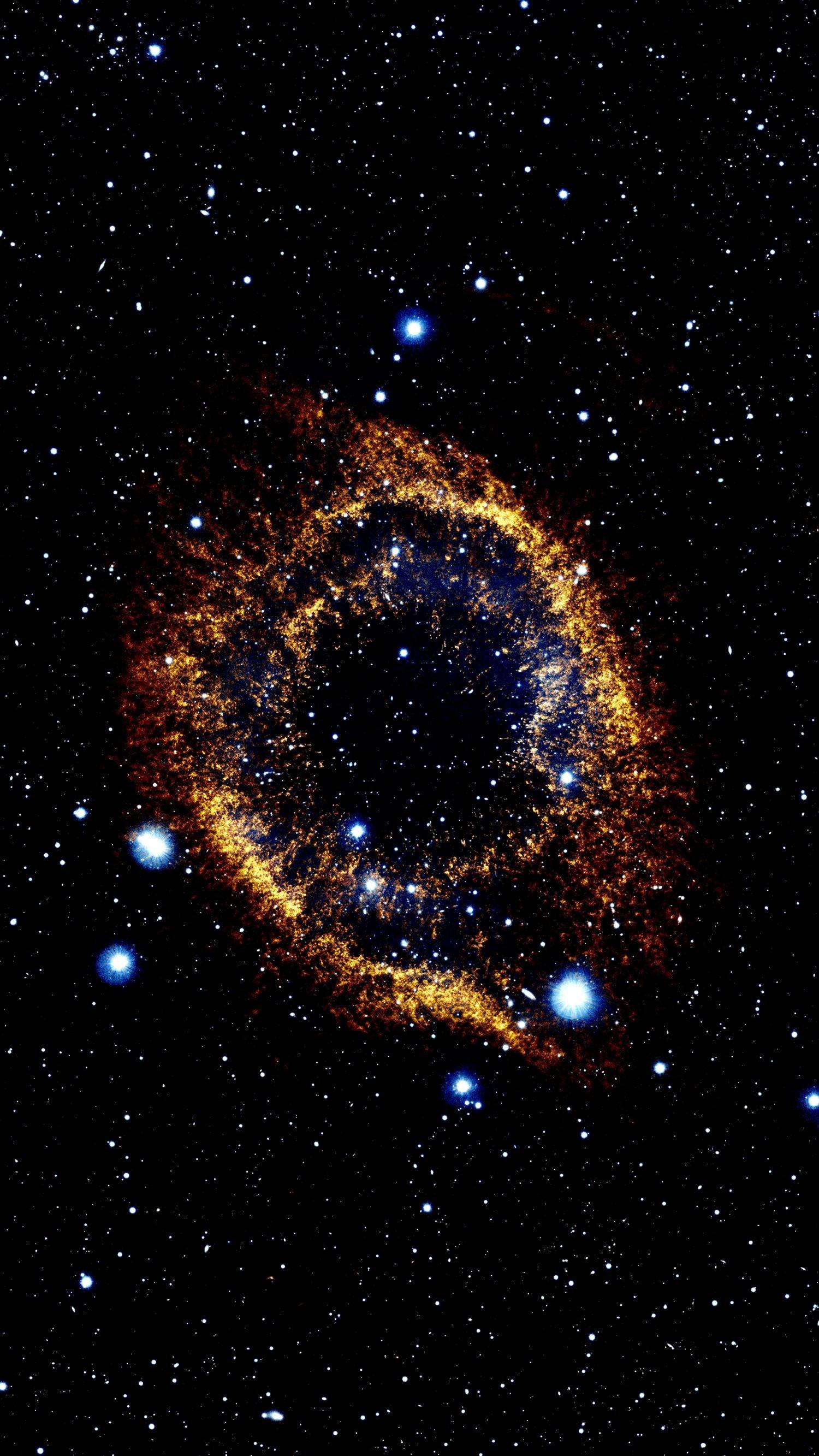 AMOLED 宇宙星系 壁紙 — 一個發光的金色環狀星雲在星空中旋轉，明亮的藍色星星散落在黑色虛空中。
