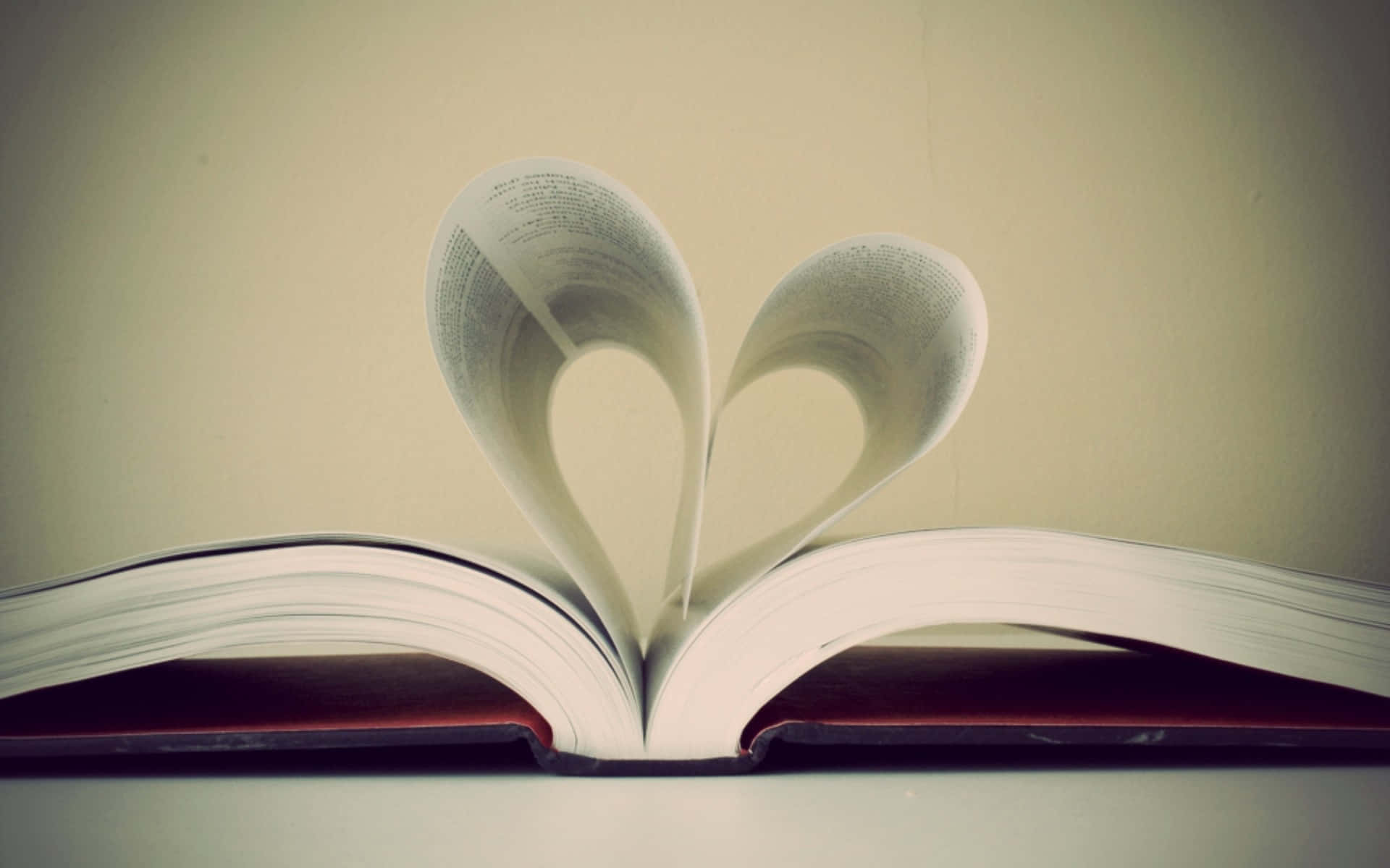 I Love God 桌布 壁紙 — 一本打開的書，書頁捲成心形，襯以柔和的米色背景。