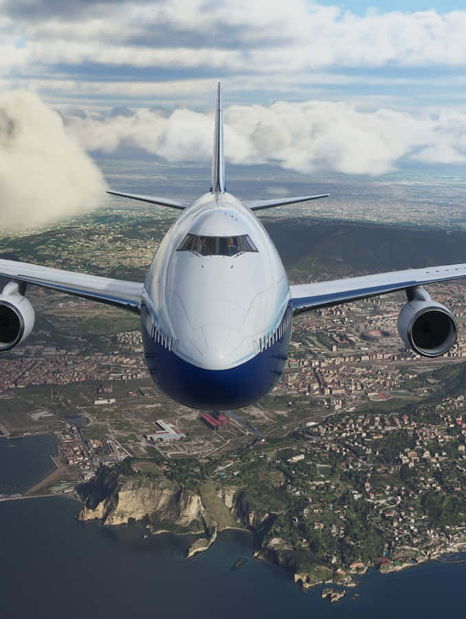 於 Android Microsoft Flight Simulator 飛向天空 壁紙 — 一架大型客機飛越一個擁有懸崖和海洋的沿海城市上空，天空部分多雲。