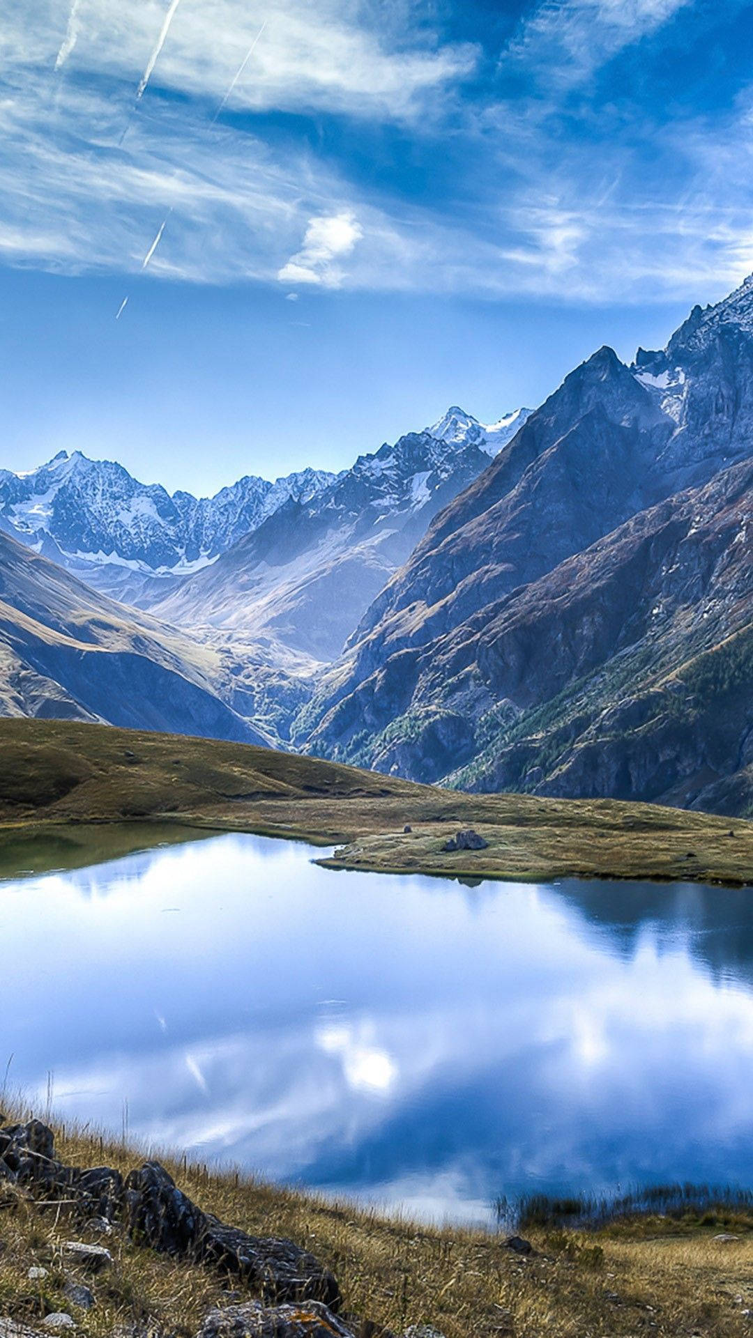 湖畔山景 Android 全高清壁紙 壁紙 — 寧靜的高山湖泊在明亮的日光下倒映著白雪覆蓋的山峰和藍天。