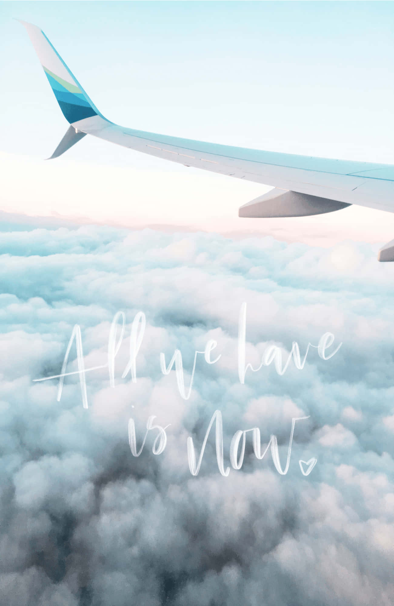 飛機尾翼穿雲 Android Travel 背景 壁紙 — 飛機機翼喺 fluffy 雲層上面滑翔，配以柔和粉彩天空同埋勵志草書文字『All we have is now.』
