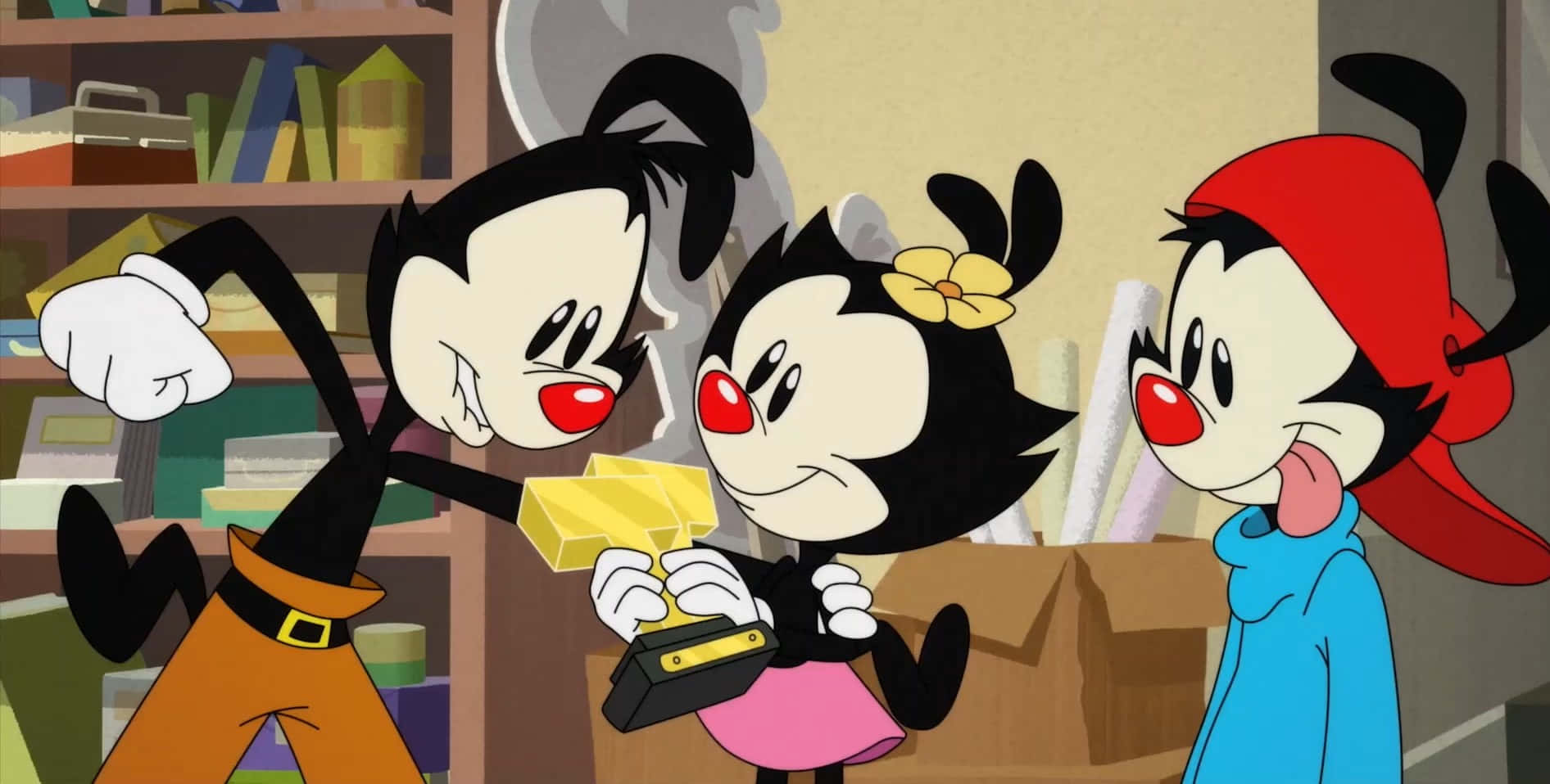 Animaniacs 帶來歡笑與歡樂 壁紙 — 三個黑髮紅鼻的卡通角色在一個堆滿書籍和盒子的雜亂房間中互動。