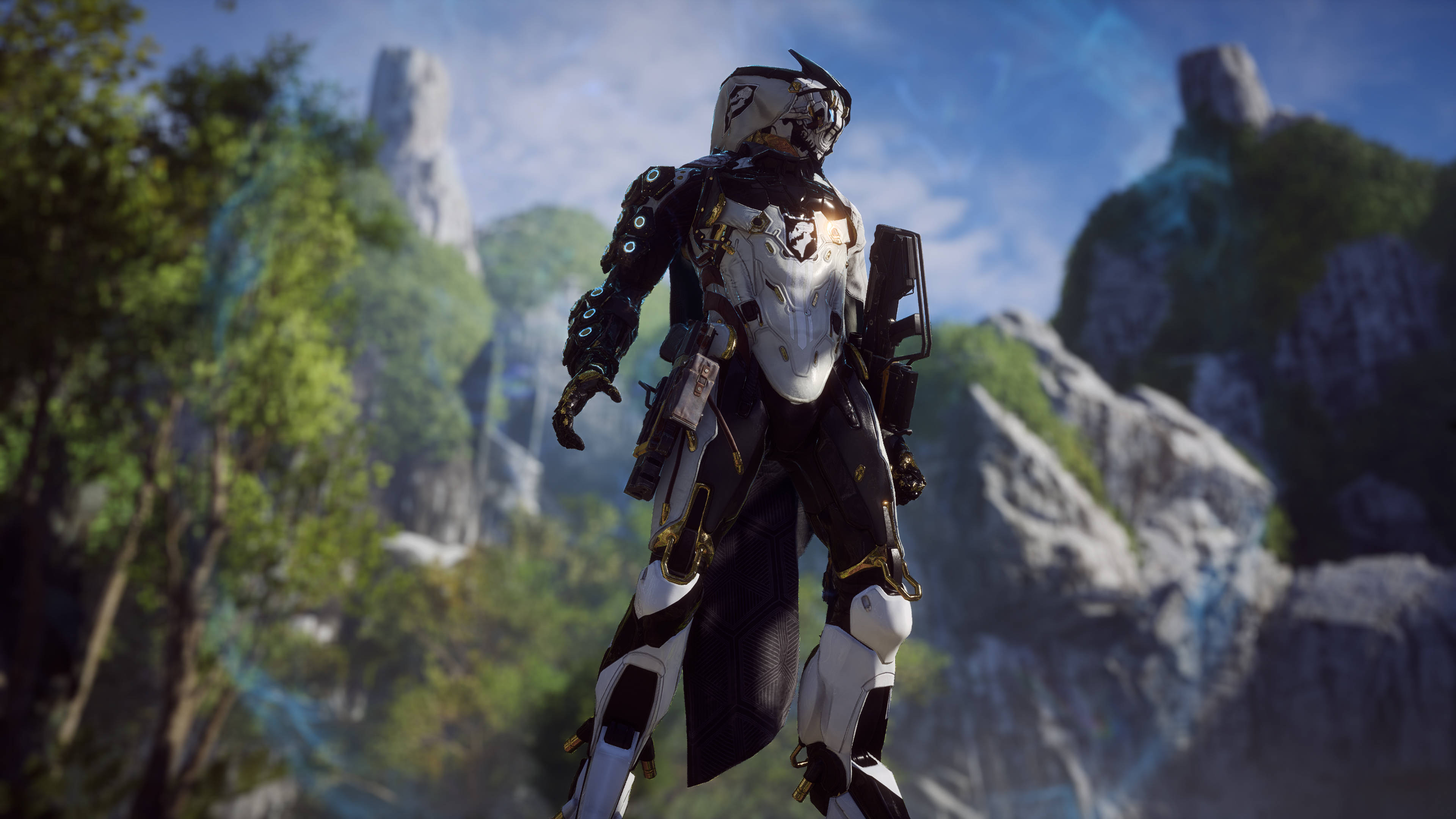 Anthem 4K 山脈 壁紙 — 一個未來風格的裝甲戰士站在一個茂密的山谷中，周圍有高聳的岩石 formations 和鮮豔的綠色植物，在明亮的藍天下。