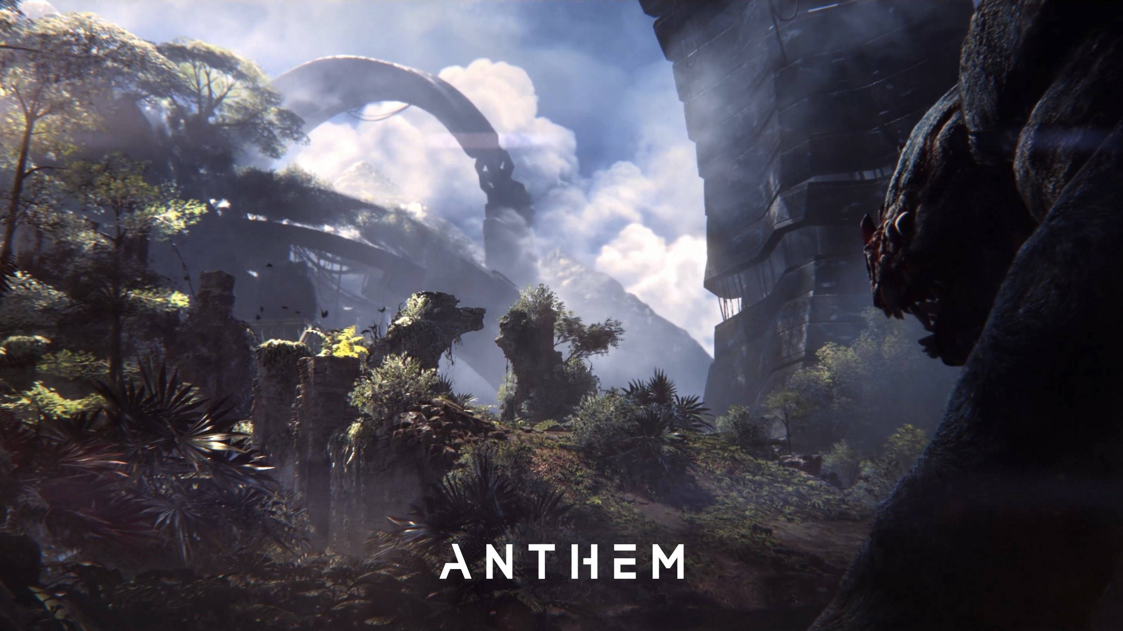造訪《Anthem》中的神祕要塞 壁紙 — 多雲天空下，霧氣瀰漫的叢林景觀，有古老石頭廢墟和巨大的拱門。