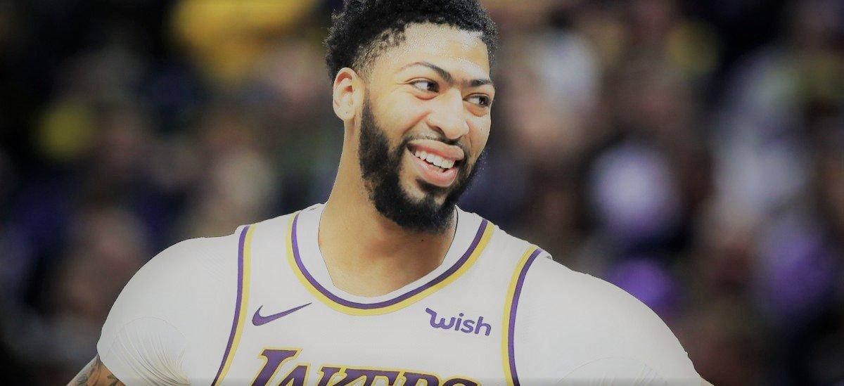 專業籃球運動員在比賽中穿著湖人隊球衣微笑。