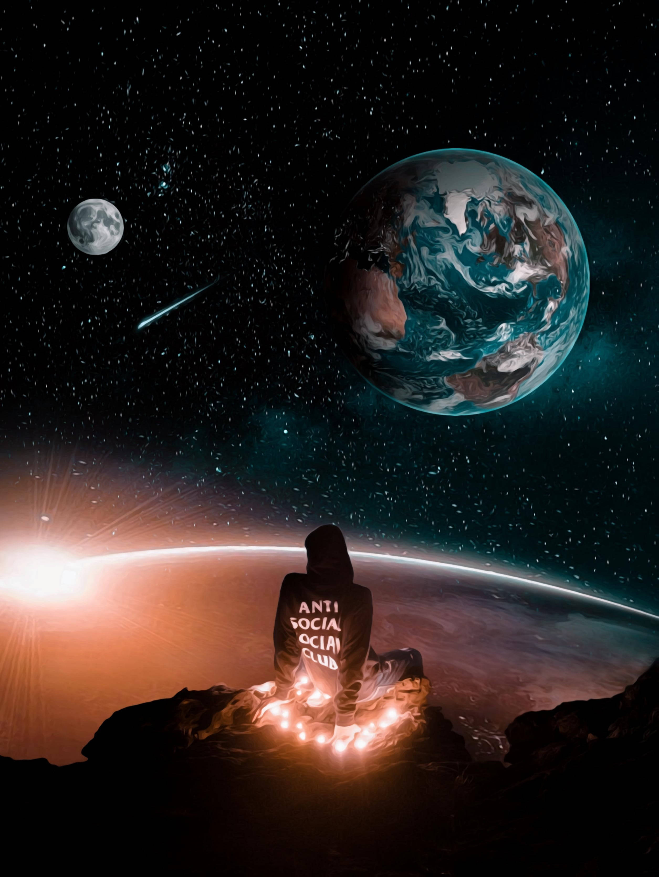 Anti Social Social Club 外太空 壁紙 — 一個戴著兜帽的身影坐在岩石上，凝視著發光的地球和月亮，背景是星空和流星。