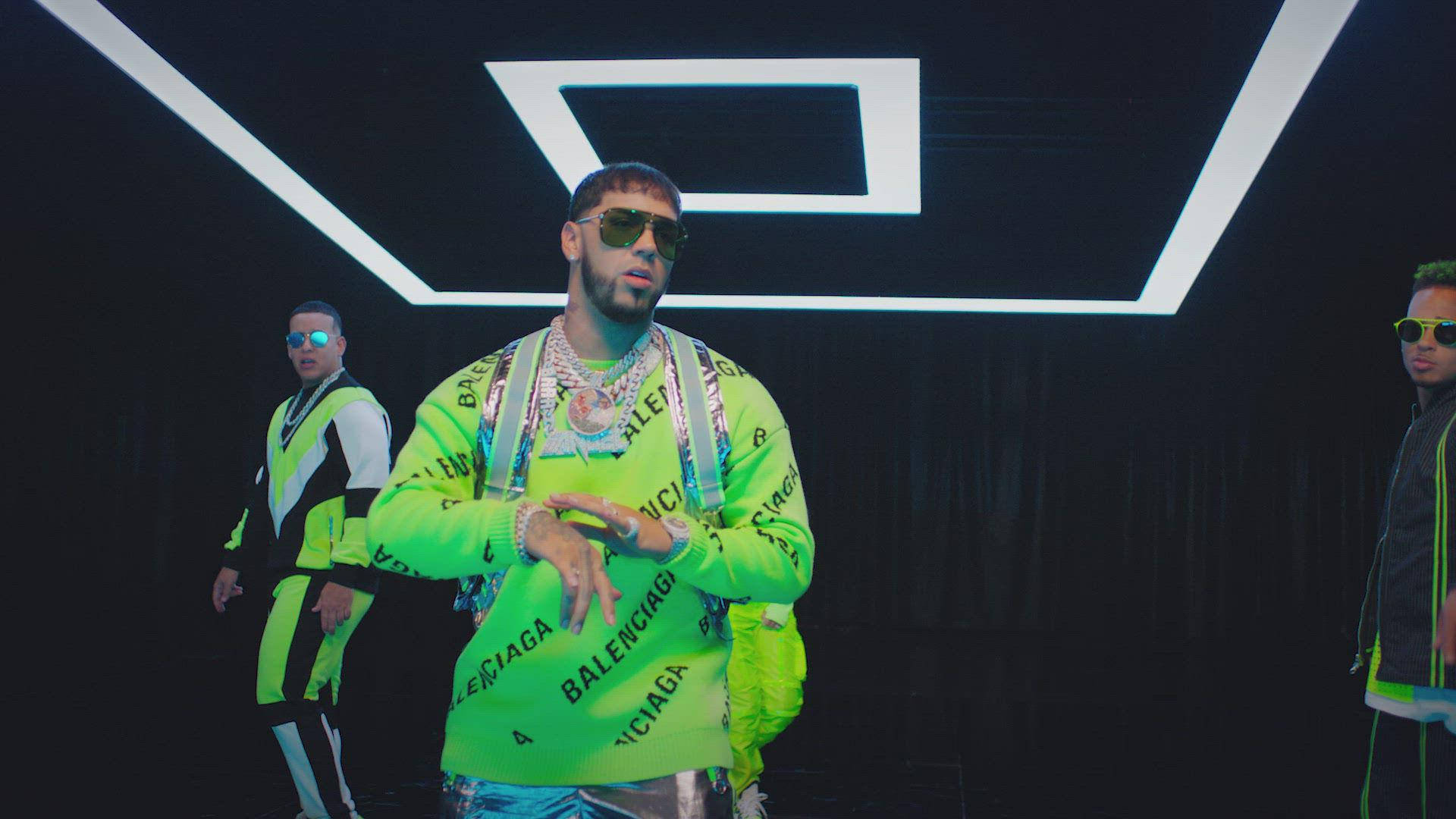 Anuel AA 中國音樂錄影帶 壁紙 — 三名身穿螢光綠色Balenciaga服裝的男士在黑暗的工作室中，在發光的幾何燈光下自信地擺姿勢。