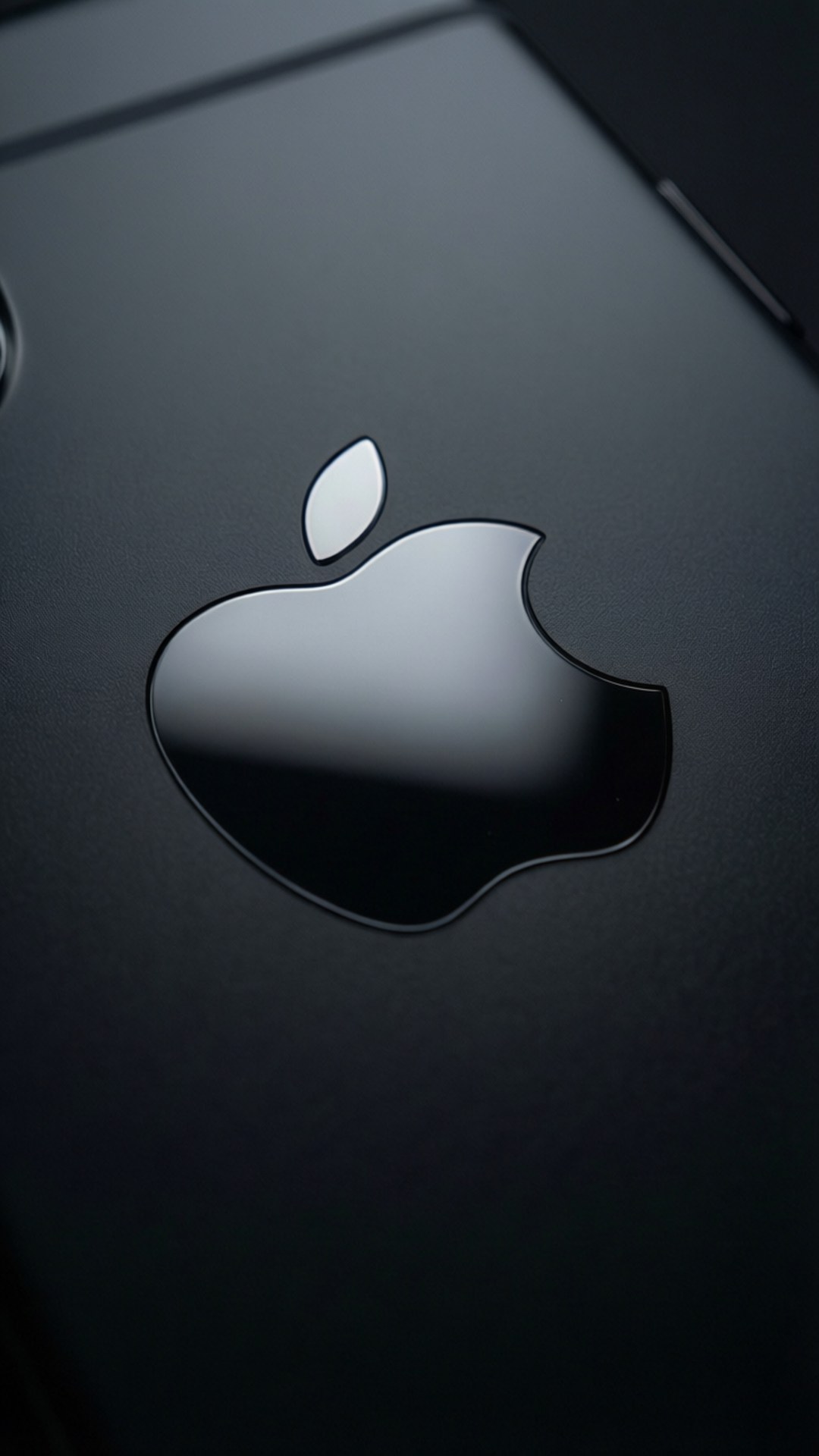 黑色設備上Apple標誌特寫，表面光澤