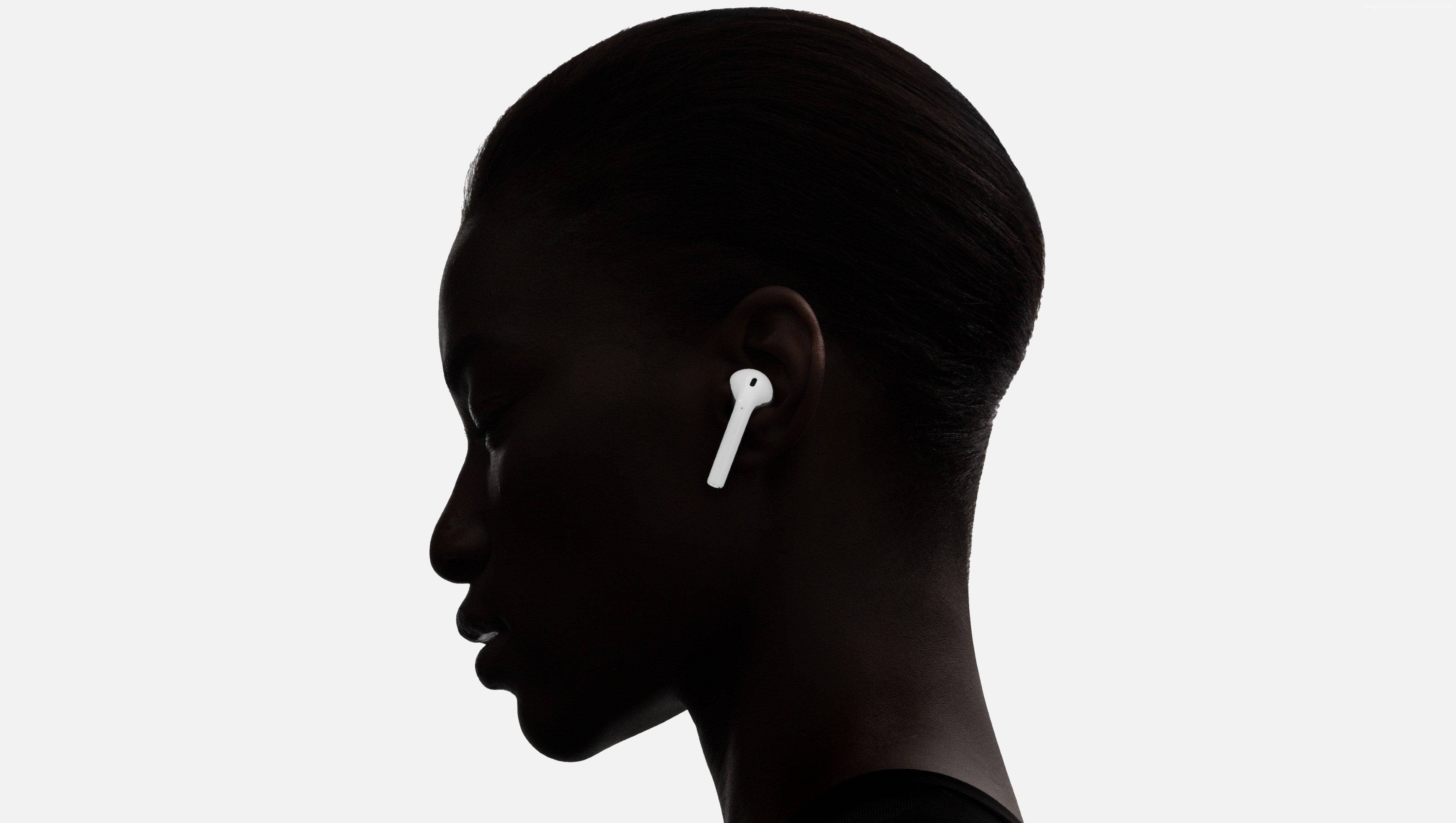 佩戴 Apple AirPods 的女性 壁紙 — 一個人嘅側面剪影，戴住白色無線耳機，背景係純色淺色。