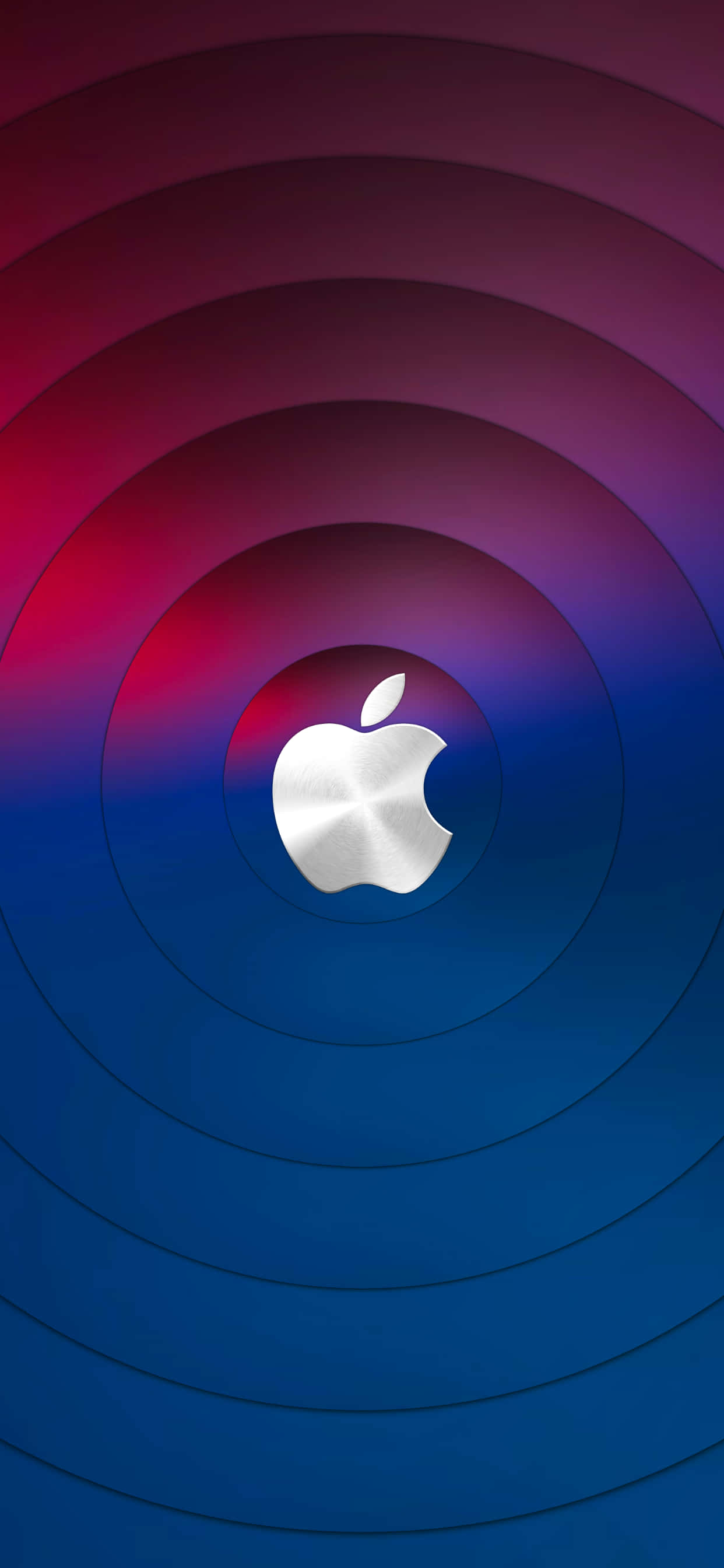 Apple iPhone 家族最新成員 — iPhone 13 壁紙 — 一個時尚的銀色Apple標誌，居中於從深紅色過渡到鮮豔藍色的同心圓環上。