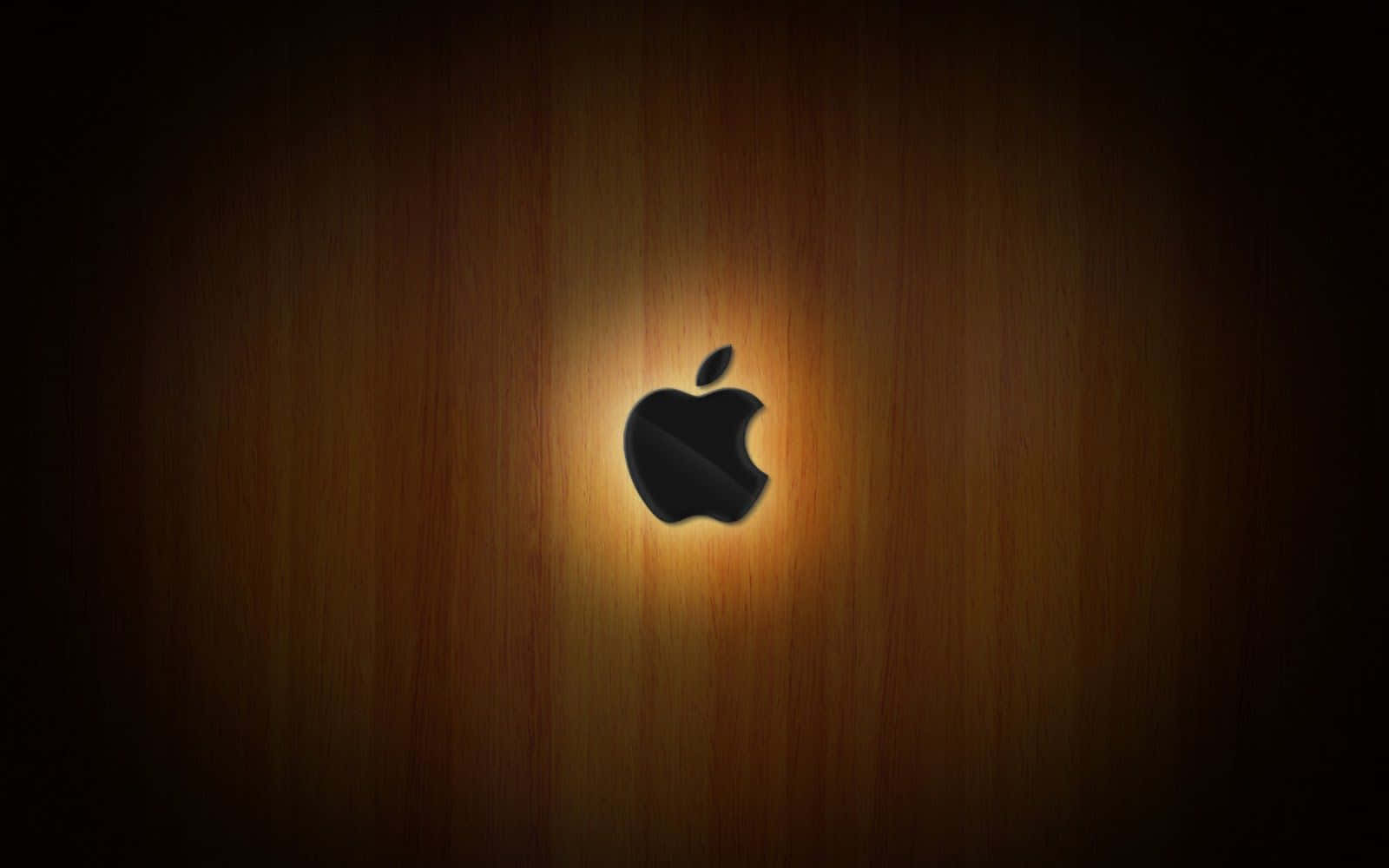 Apple Mac 桌上型電腦標誌背光效果 壁紙 — 一個時尚的黑色Apple標誌在溫暖的木質背景上柔和發光，帶有放射光效果。