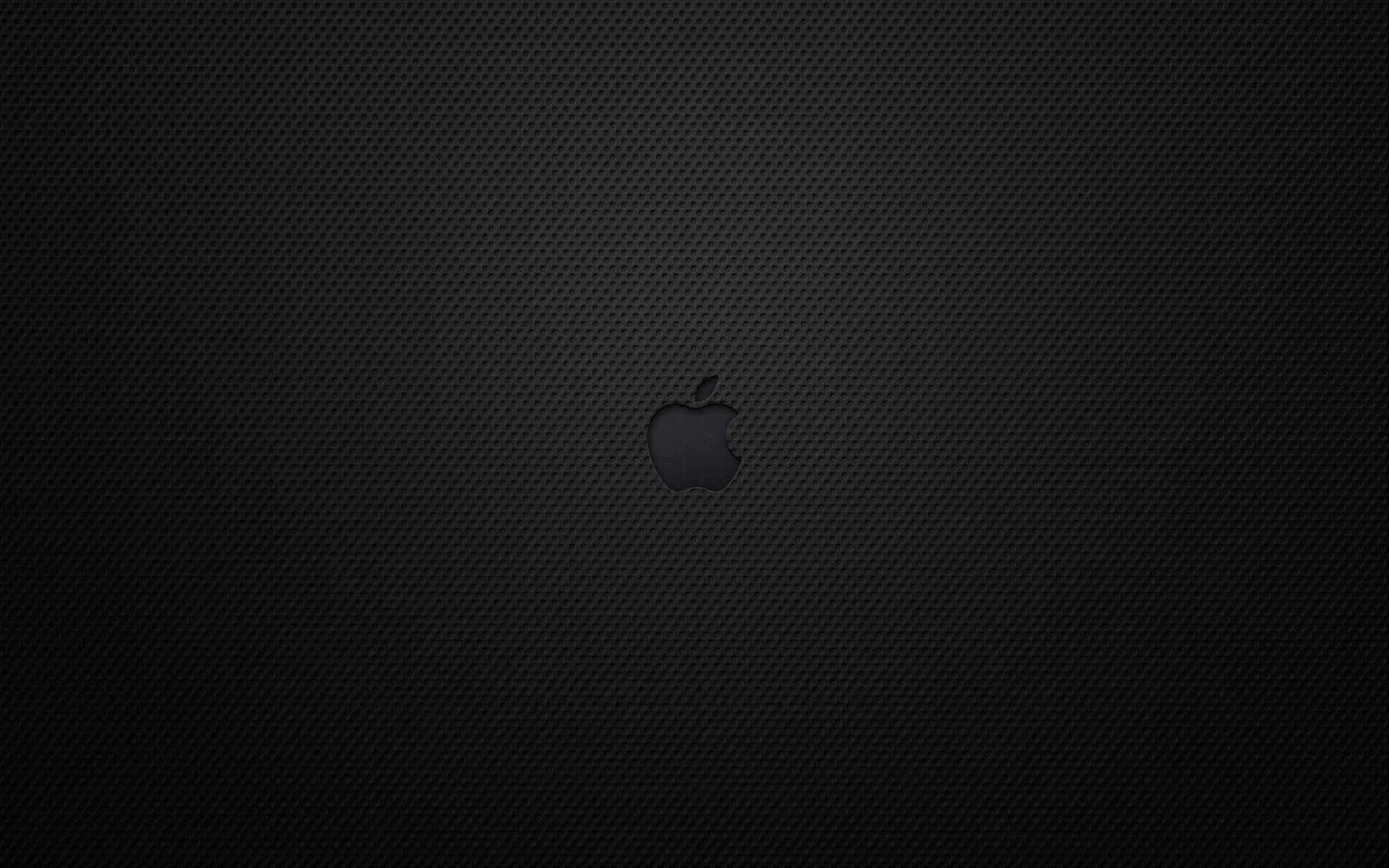 以 Apple 標誌性 MacBook 帶來經典黑色之美 壁紙 — 一個極簡的黑色Apple標誌，居中於有紋理的碳纖維背景上。