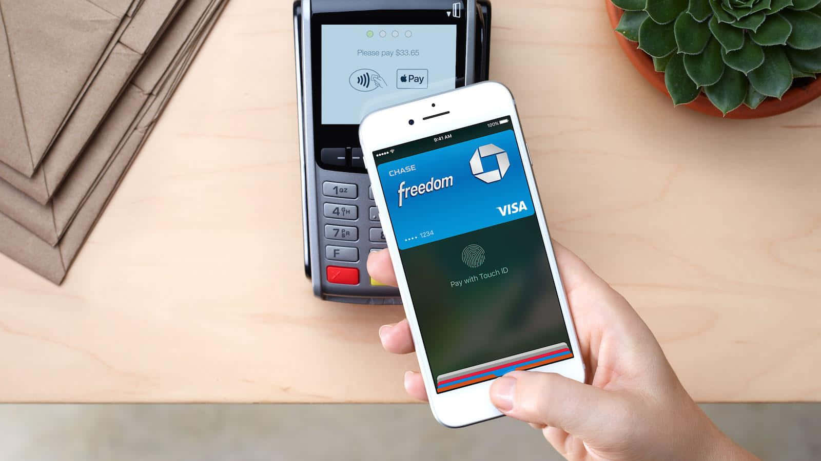 手在讀卡器使用電話透過Apple Pay以Chase Freedom Visa付款。