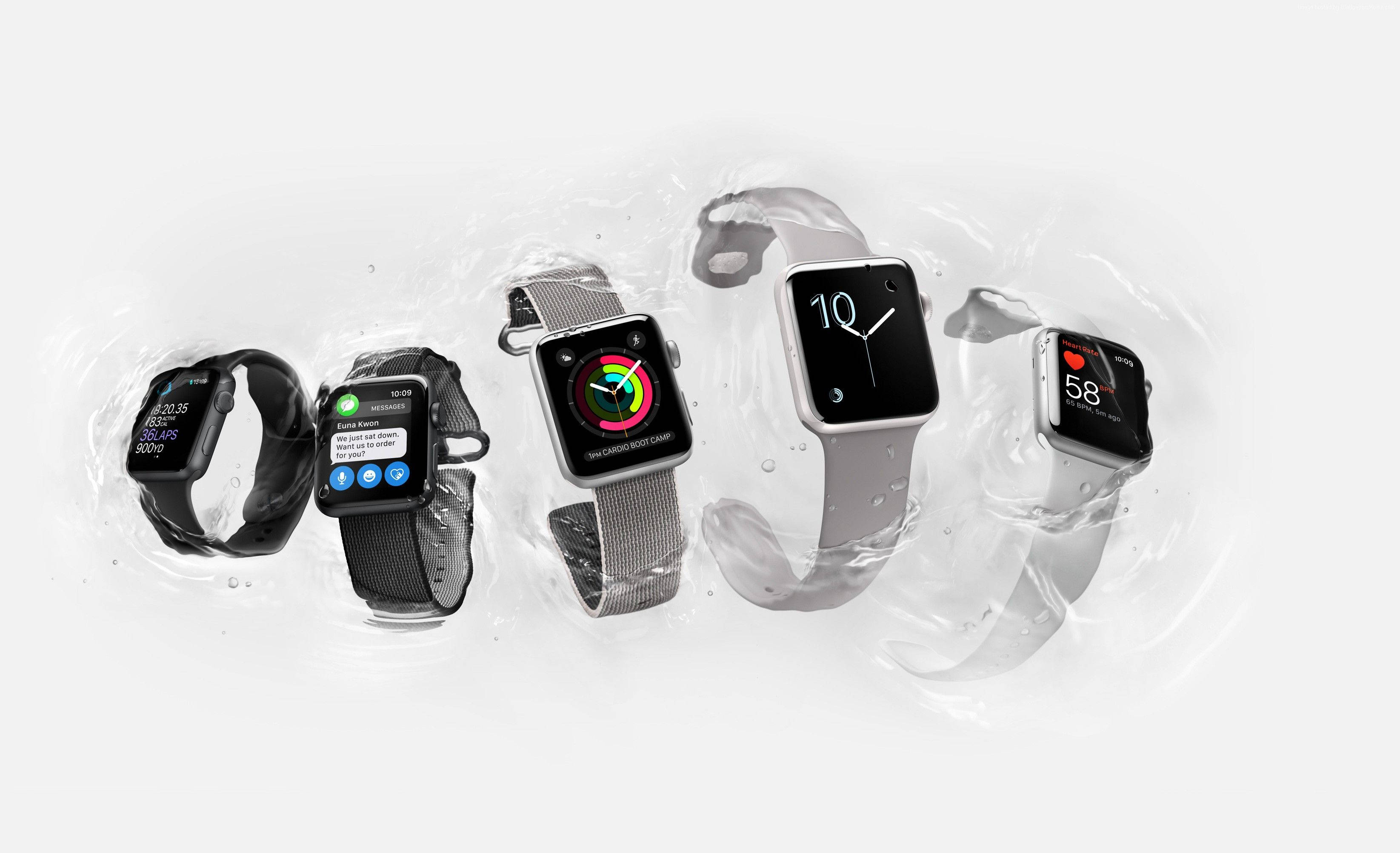 Apple Watch 黑灰配色 壁紙 — 五隻Apple Watch漂浮在清澈的水滴中，以潔白的背景展示不同的錶帶和錶面。