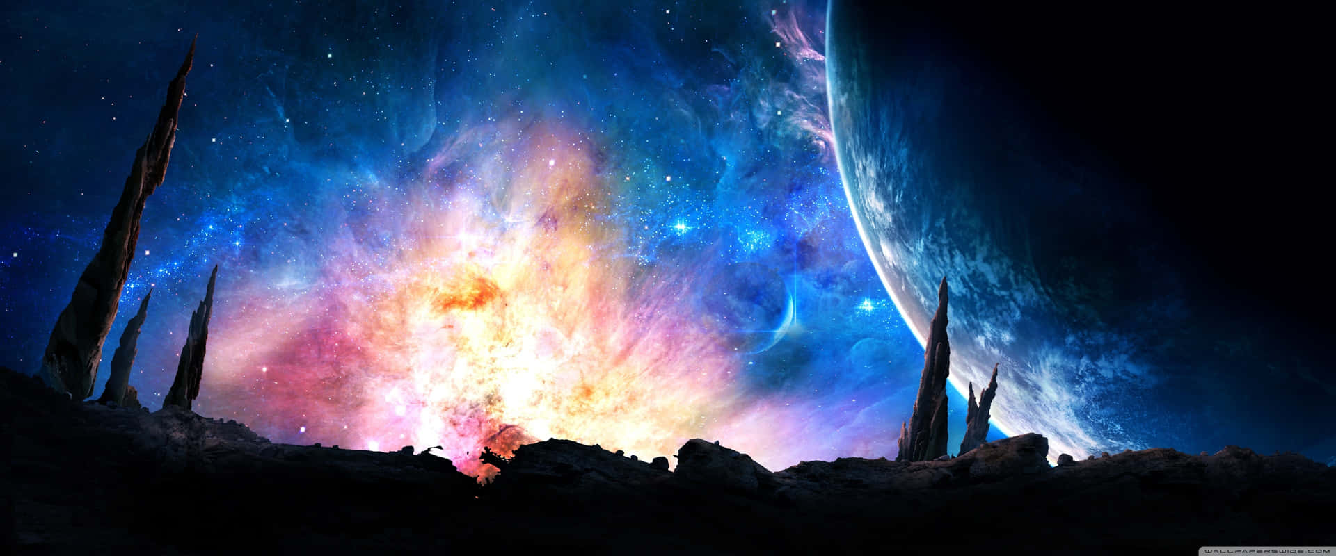 岩石尖塔在多彩星雲和發光行星背景下的剪影。