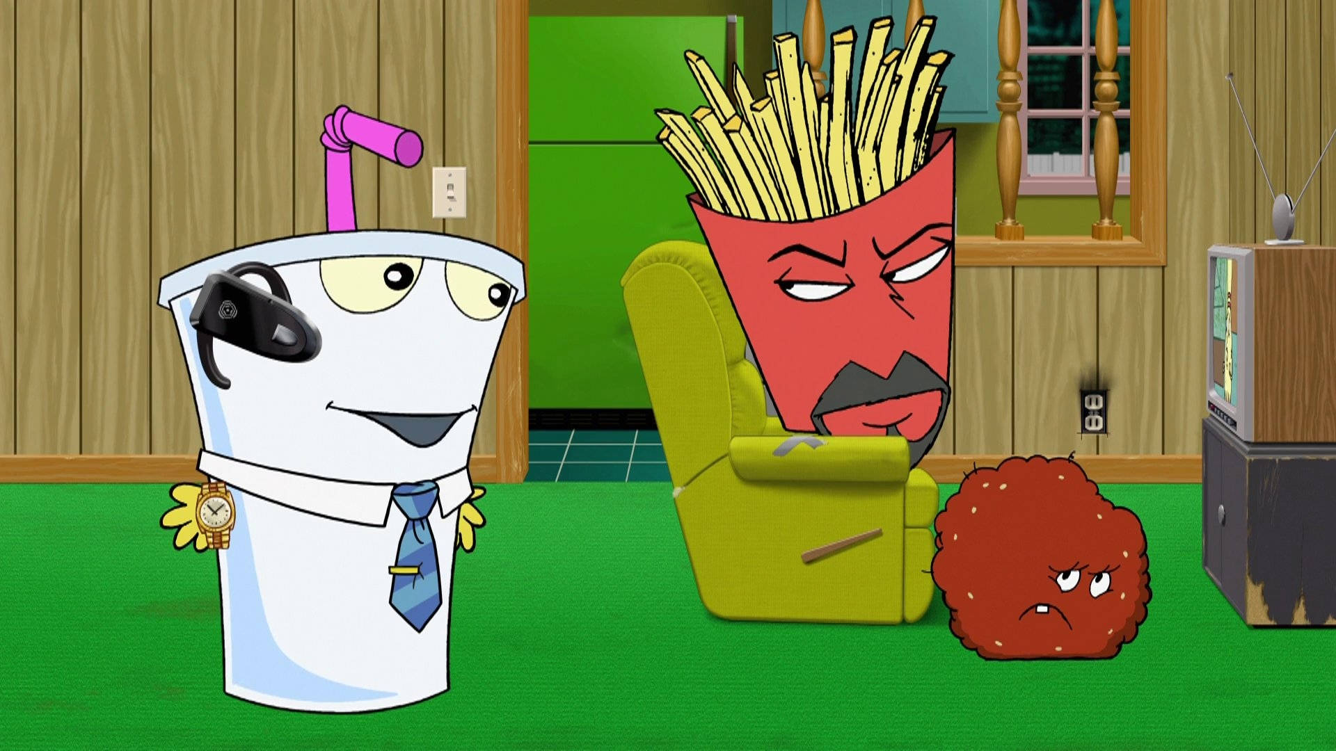 《Aqua Teen Hunger Force》會議時刻 壁紙 — 一個戴著耳機和領帶的卡通咖啡杯，站在一張綠色扶手椅旁，椅子上有一個憤怒的薯條角色，地上還有一個脾氣暴躁的肉丸。