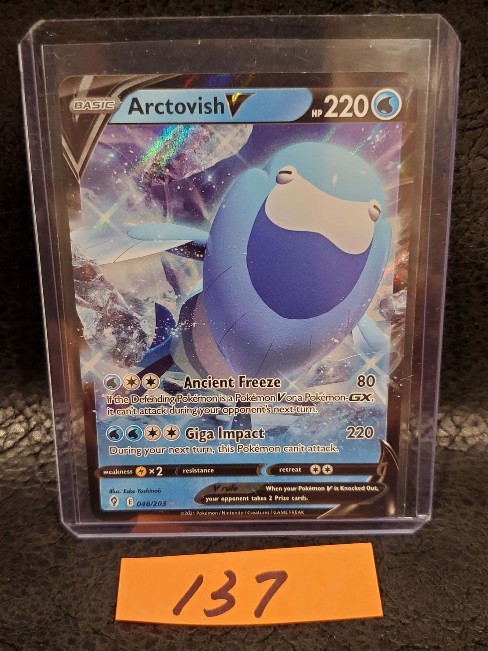 Arctovish 寶可夢卡動態展示 壁紙 — 一張藍色Arctovish V Pokémon卡放在透明保護套中，置於深色表面上，附有橙色標籤寫著137。