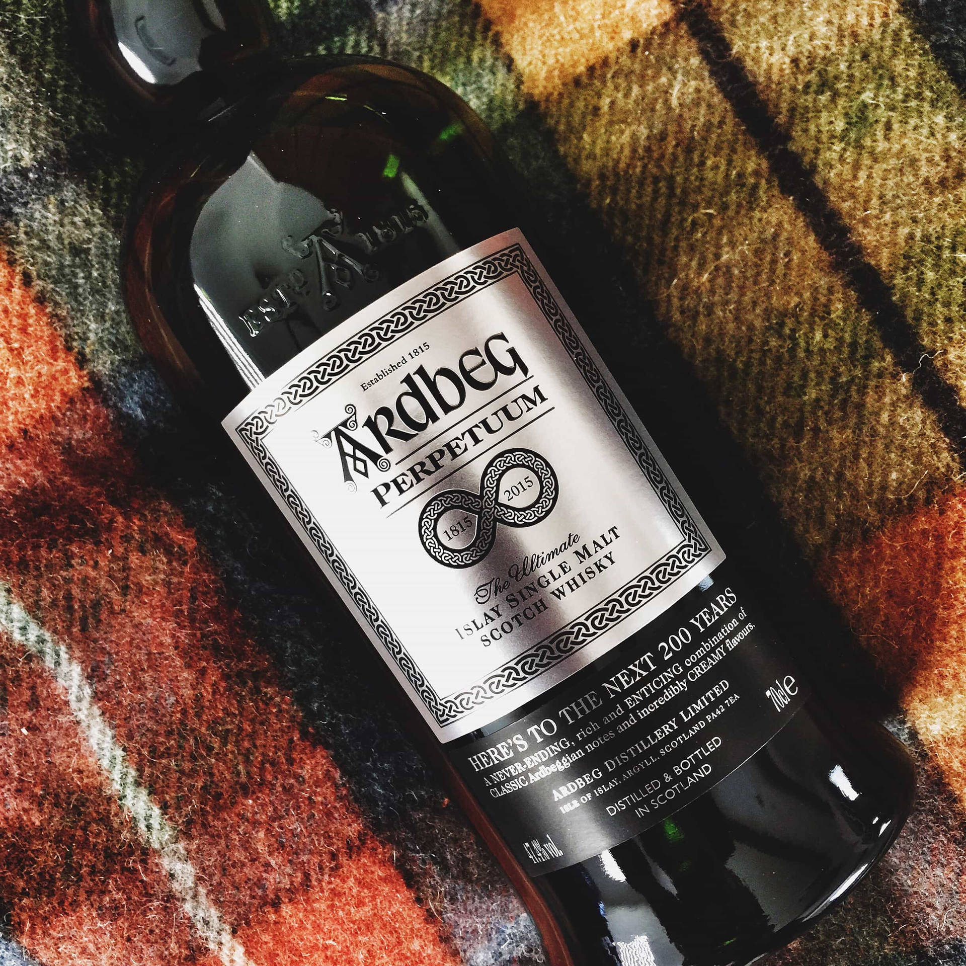 格紋毯上的一瓶Ardbeg Perpetuum威士忌。