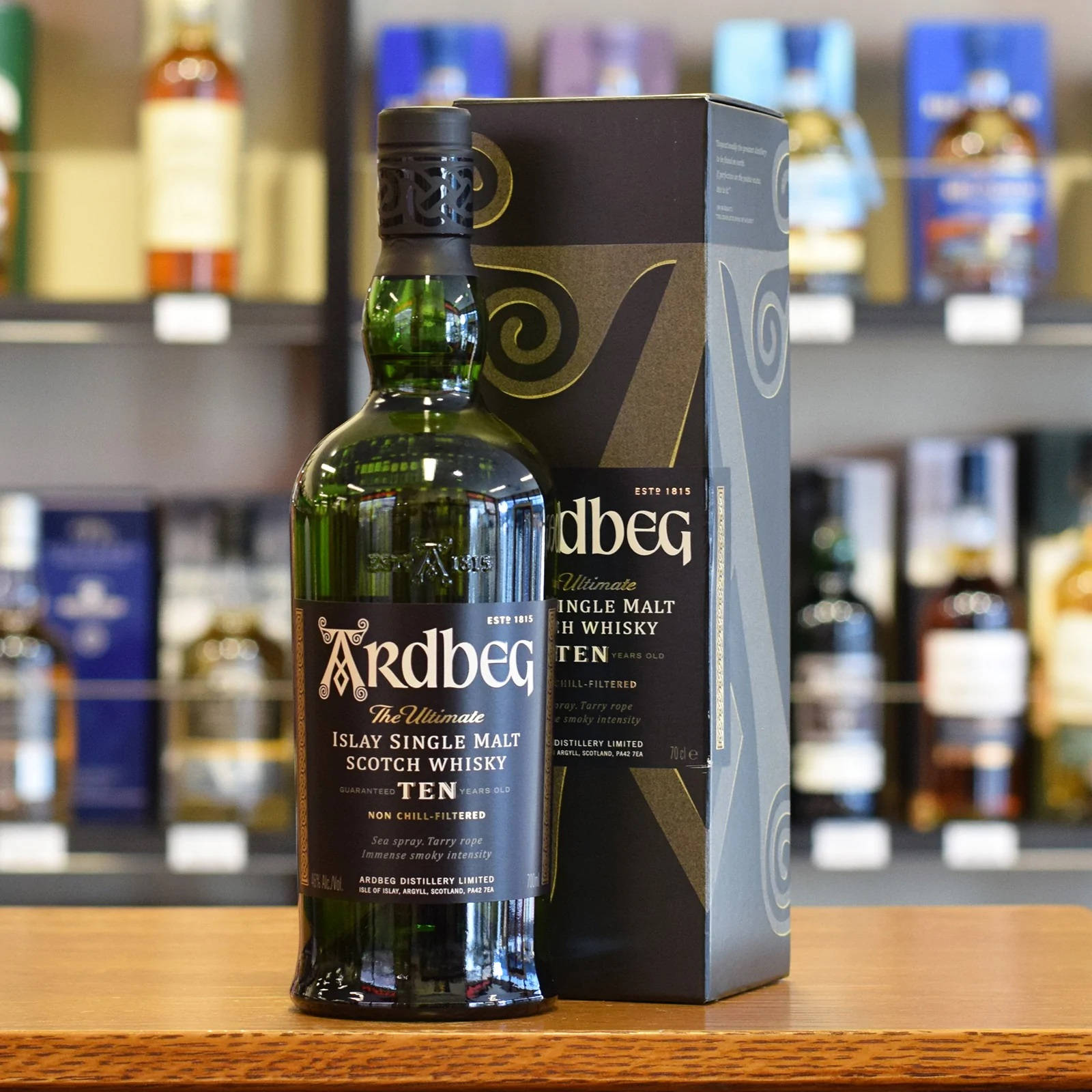 酒舖木製櫃檯上的Ardbeg Ten威士忌酒瓶和盒子。