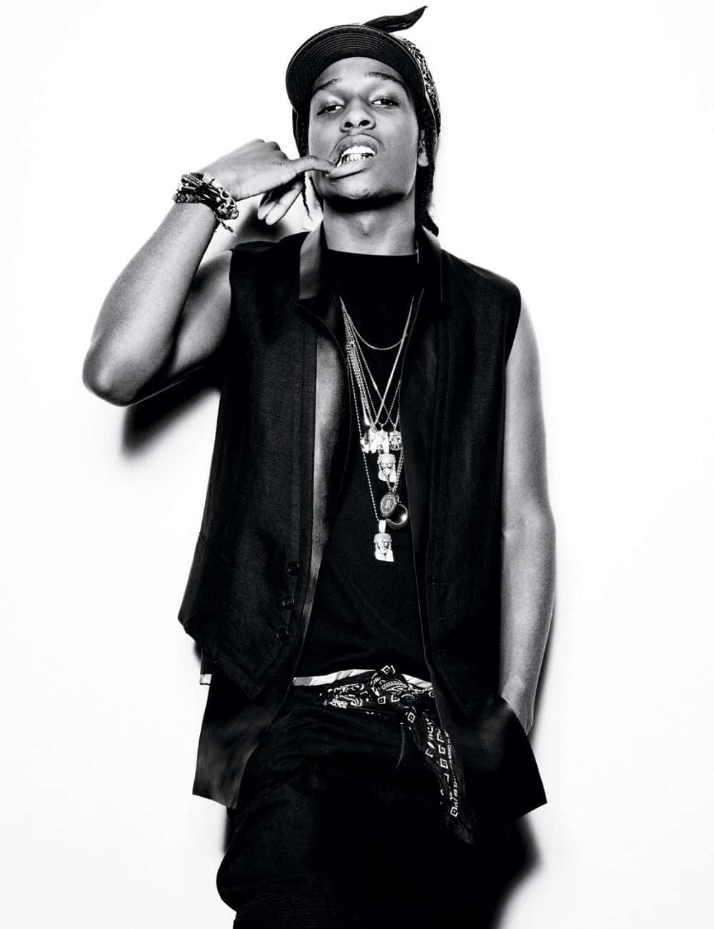 Asap Rocky 漫步沙漠 壁紙 — 一個時尚年輕男子在純白背景前，手靠近嘴巴擺姿勢的黑白肖像。