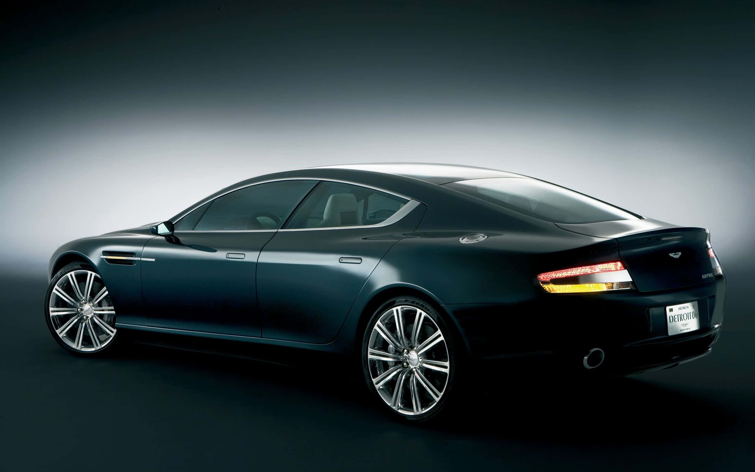 Aston Martin Rapide S - 奢華與性能並重 壁紙 — 一輛時尚的黑色 Aston Martin Rapide 在攝影棚燈光下閃耀，展現其優雅曲線和鍍鉻輪圈。