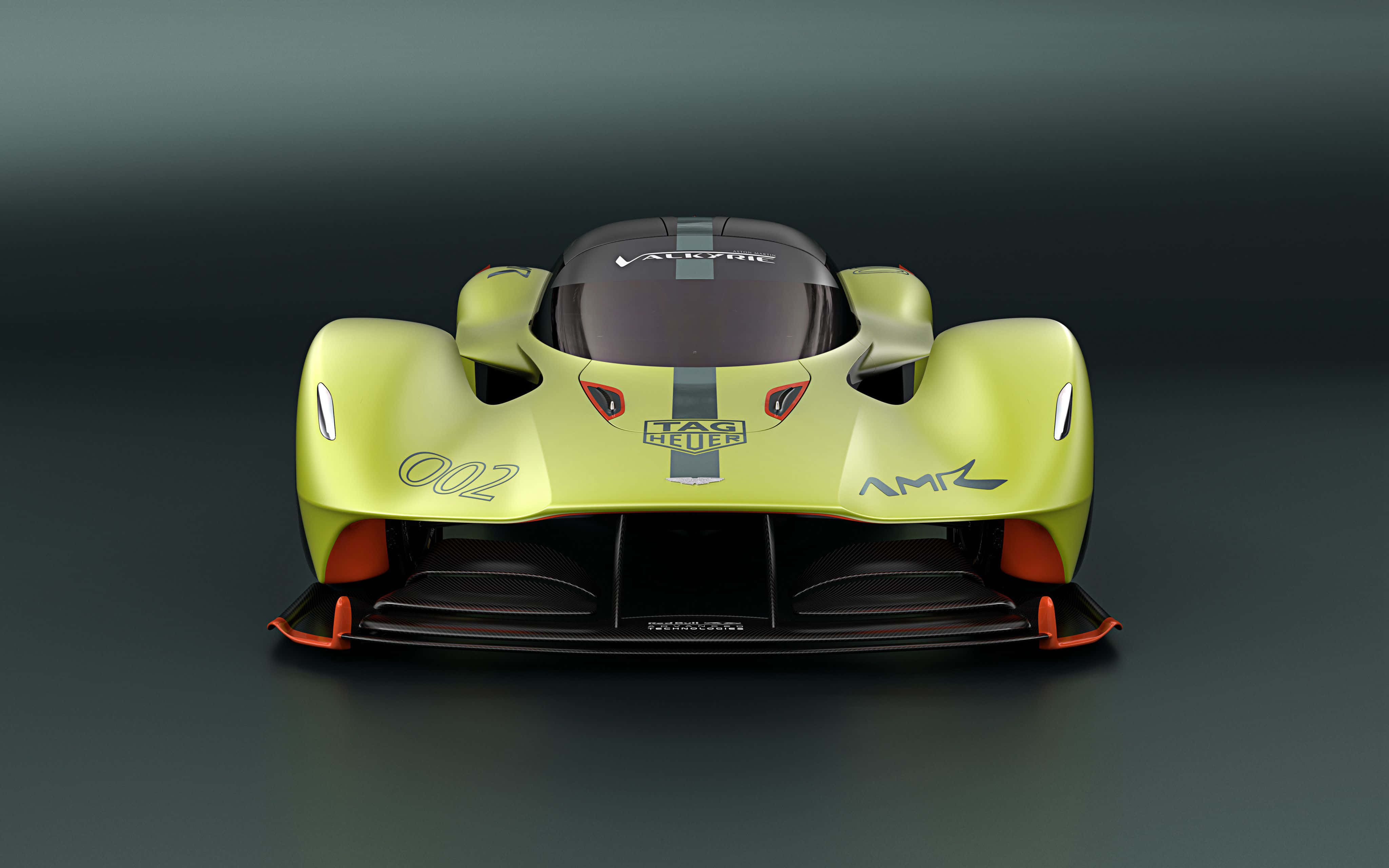 Aston Martin Valkyrie喺賽道上奔馳 壁紙 — 一輛青檸綠色超級跑車，帶有橙色點綴和「002」號碼，背景為深色攝影棚。