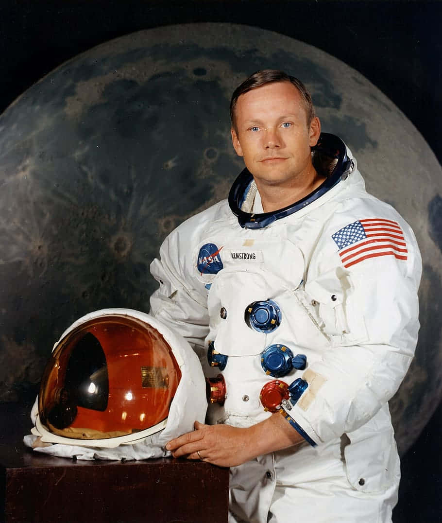 Neil Armstrong 桌布 壁紙 — 太空人尼爾·岩士唐身穿白色太空衣，站在大型月球背景前，手持頭盔。