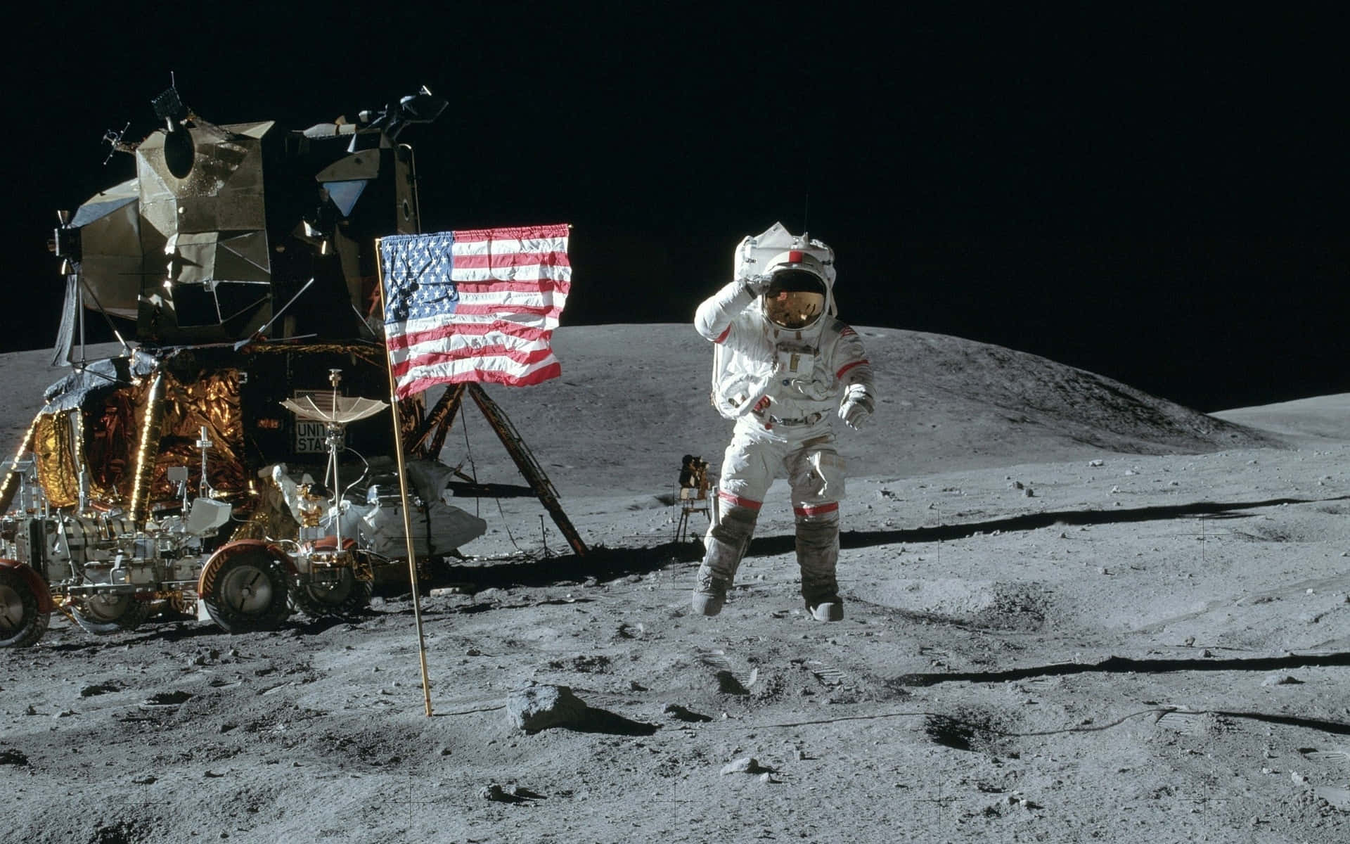 Neil Armstrong 桌布 壁紙 — 一名太空人站在月球上，旁邊是月球登陸器，並在黑色天空下揮動美國國旗。