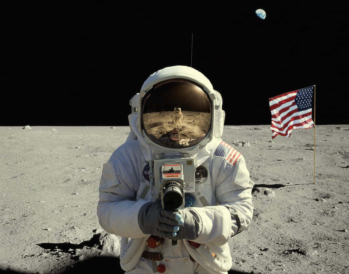 Neil Armstrong 桌布 壁紙 — 一名太空人在月球上手持相機，遠處可見地球，附近插有美國國旗。