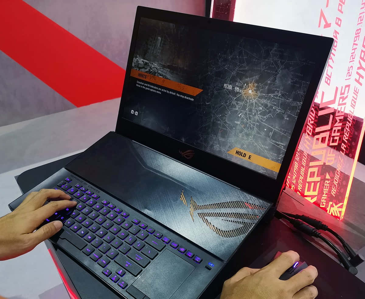 以 ASUS ROG Strix RTX™ 3090 圖形卡成為其他玩家的焦點 壁紙 — 一名玩家在黑色ASUS ROG手提電腦上玩戰術射擊遊戲，配有發光紫色按鍵和滑鼠，位於紅白品牌攤位。