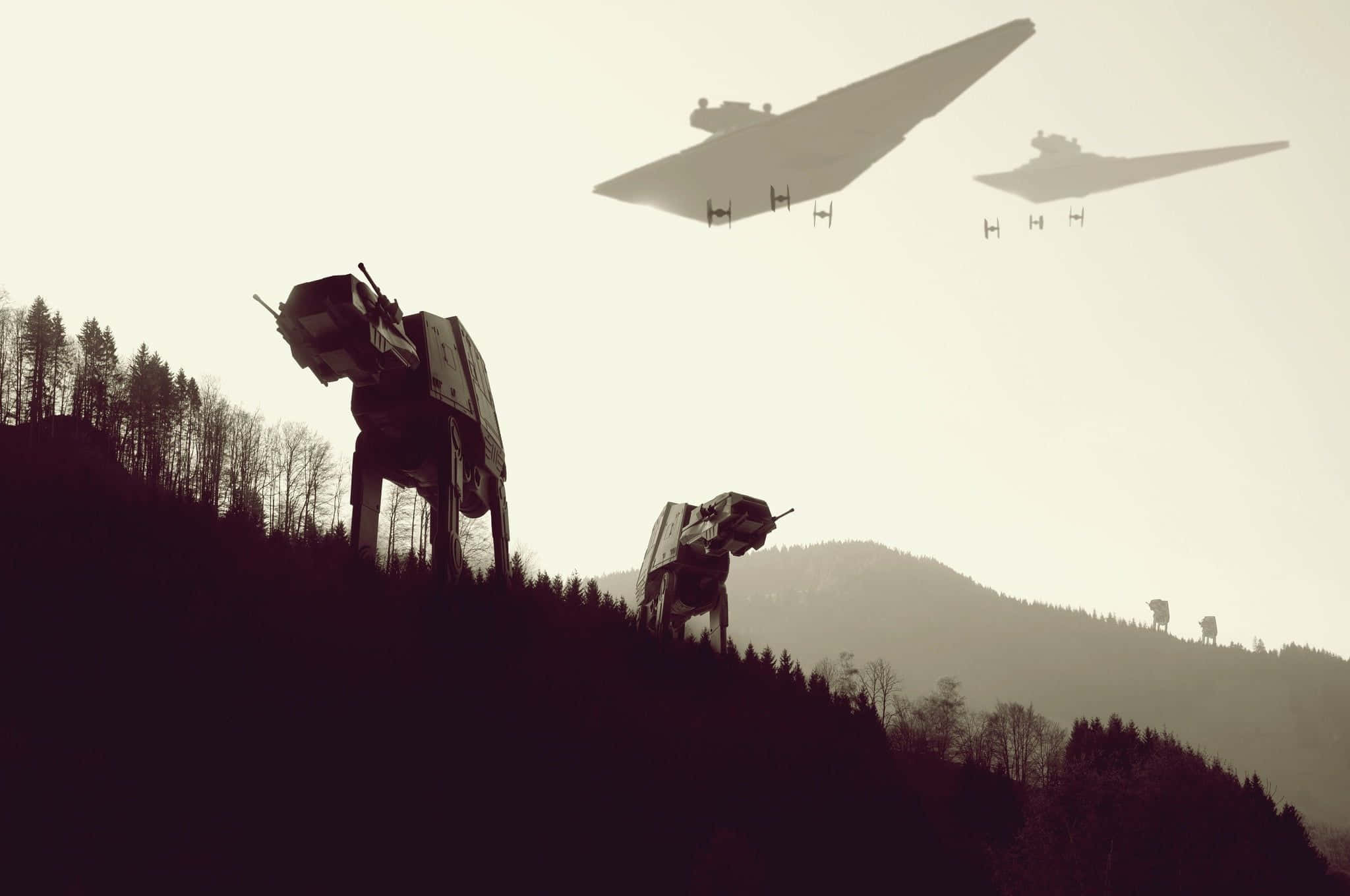 At-at 桌布 壁紙 — AT-AT步行機和星際戰鬥機的剪影聳立在霧氣瀰漫的天空下，森林覆蓋的山脈之上。