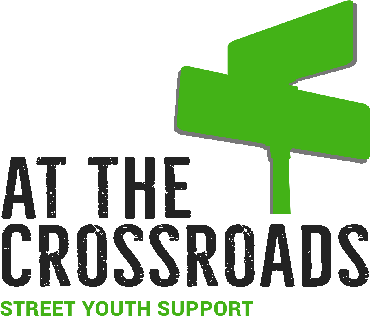 At The Crossroads 標誌 壁紙 — 一個大膽的綠色風格化十字路口標誌，帶有磨損的灰色文字 'AT THE CROSSROADS STREET YOUTH SUPPORT'，背景為黑色。