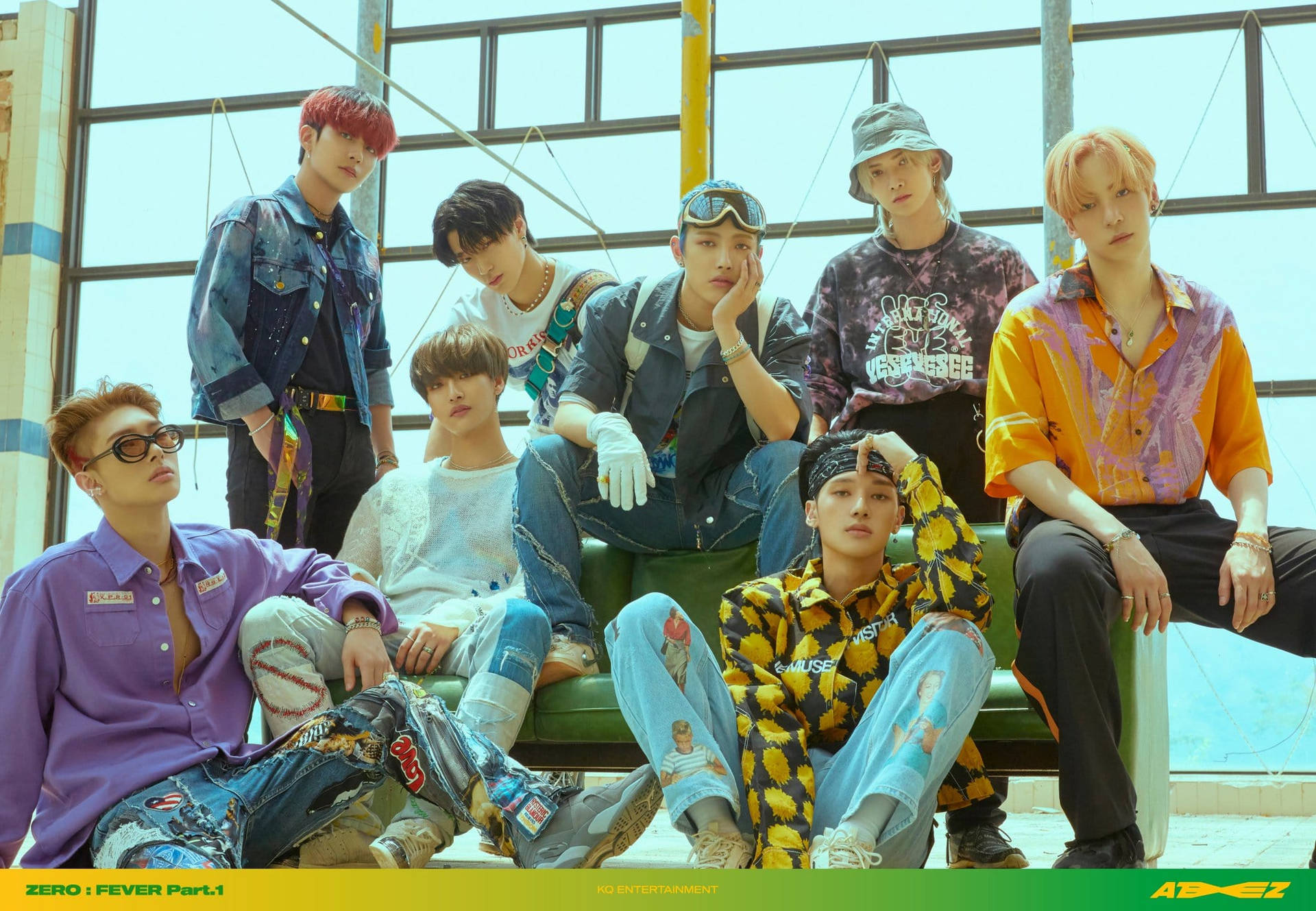 ATEEZ穿時尚服裝桌面 壁紙 — 七位時尚年輕男子身穿色彩繽紛的街頭服飾，在明亮的工業風格窗戶下的綠色長椅上自信地擺姿勢。